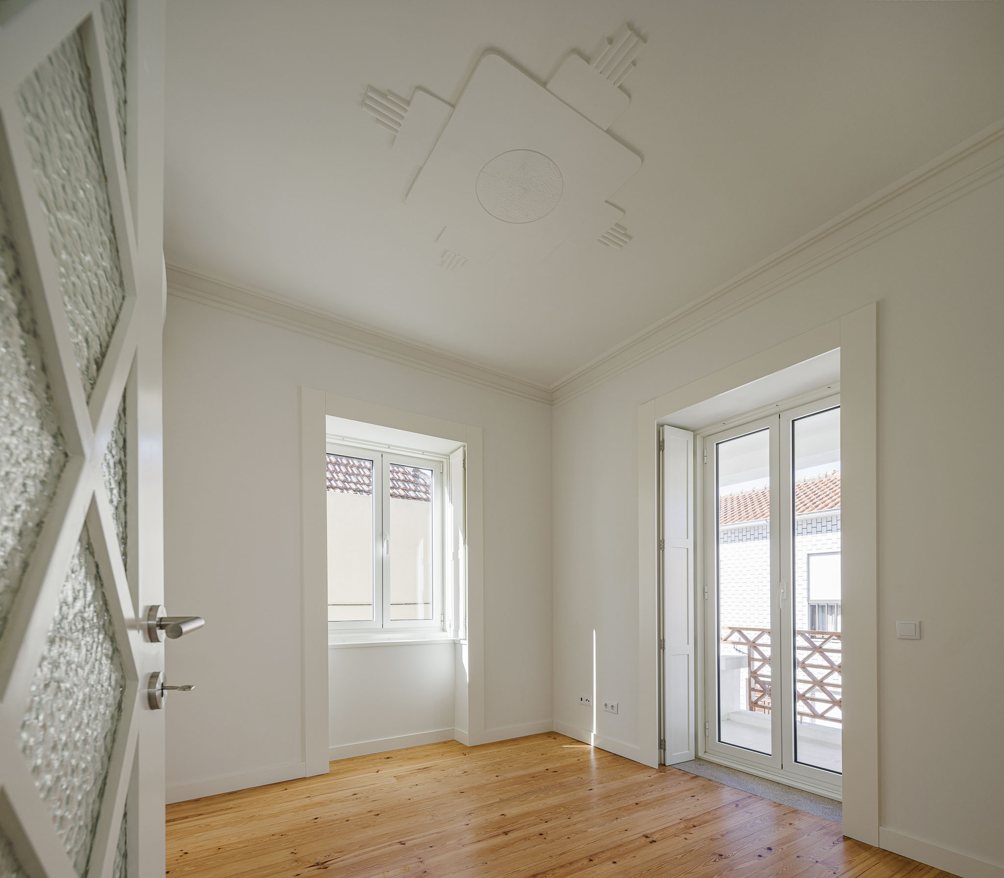 Quarto: Quarto com pavimento em madeira clara, janelas com portadas e porta com vidro trabalhado. — Casa dos anos 40 arquitetura Frari em Ílhavo