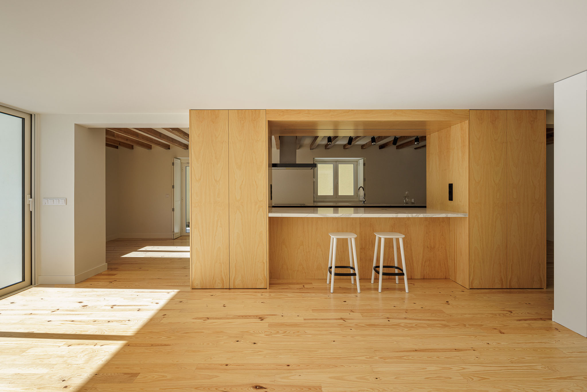 Cozinha: Cozinha ampla com ilha central, armários em madeira clara e pavimento em madeira clara. — Casa dos anos 40 arquitetura Frari em Ílhavo