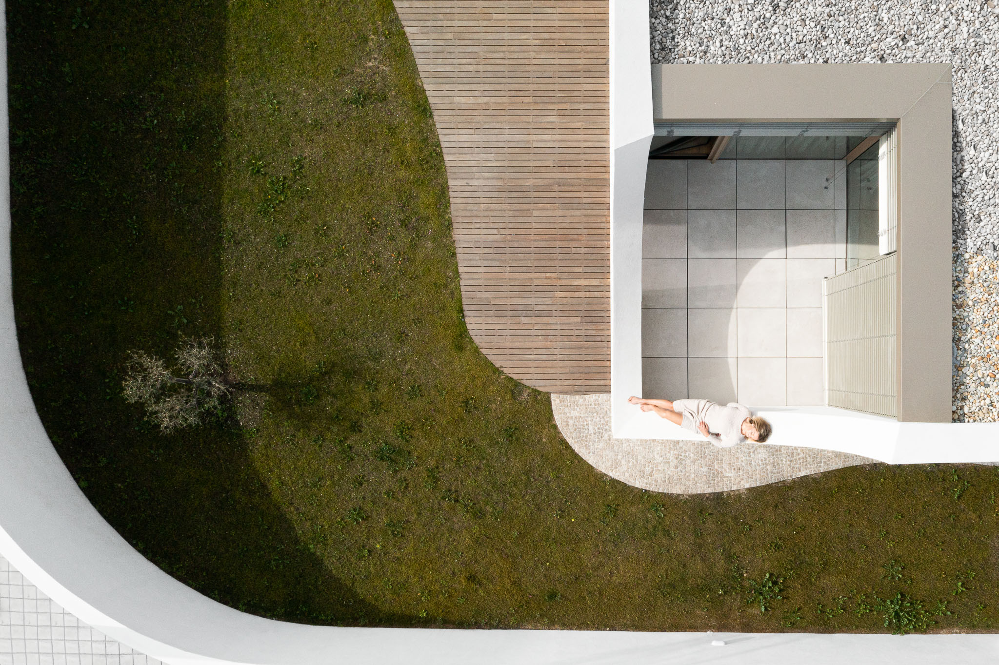 Jardim: Vista aérea do jardim com relvado, deck de madeira e varanda cerâmica. — Casa Pátios de Pétalas arquitetura Sandra Micaela Casinha Atelier em Gondomar