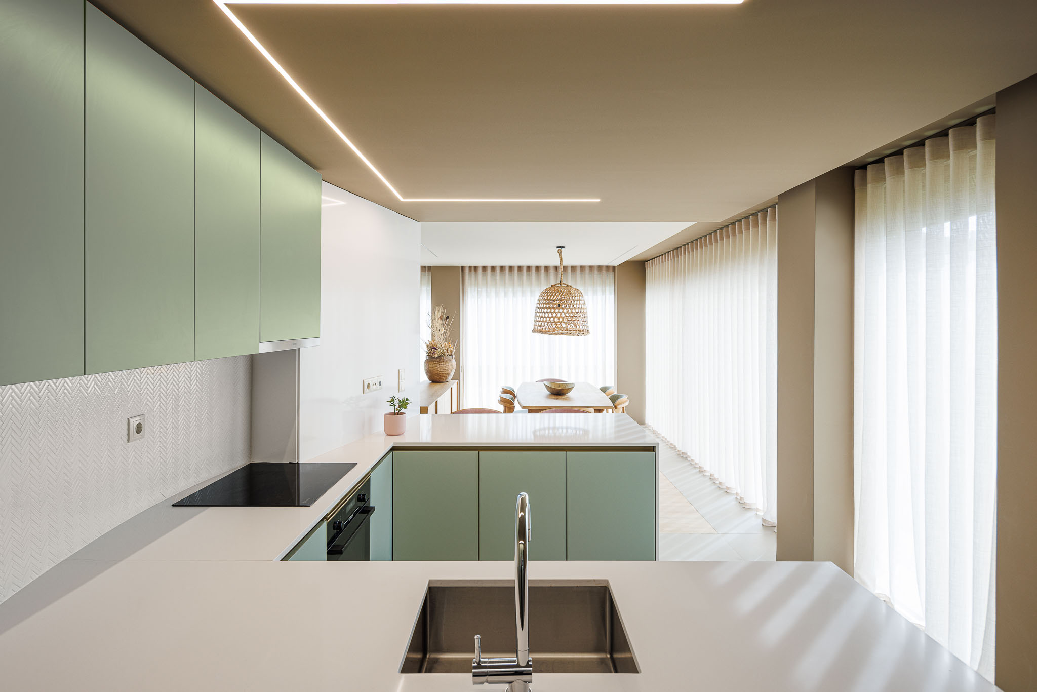 Cozinha: Armários verde-água, bancada branca e vista para a sala de jantar. — Casa Pátios de Pétalas arquitetura Sandra Micaela Casinha Atelier em Gondomar