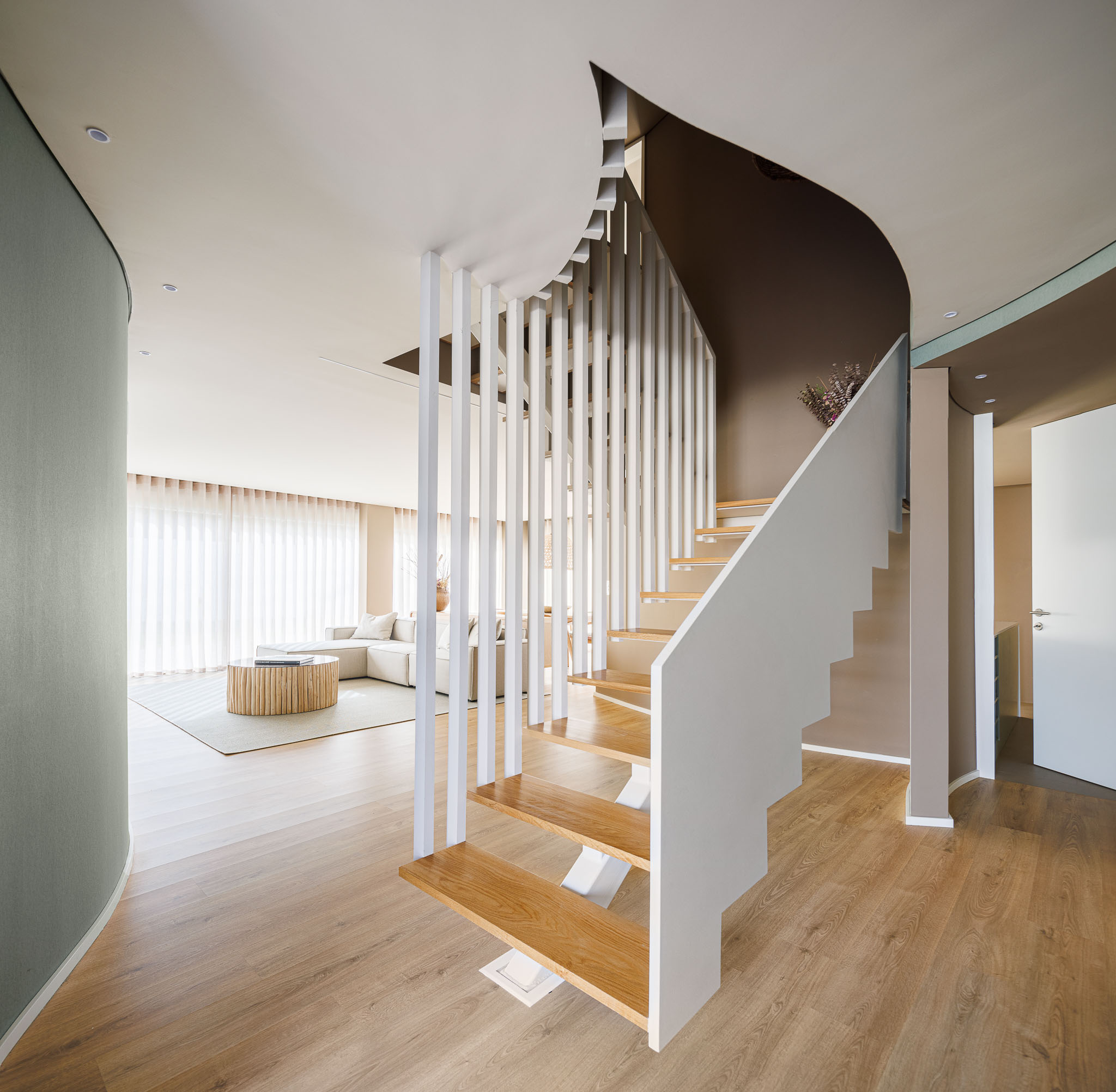 Escadas: Escadas em madeira com guarda em ripas verticais brancas e vista para a sala de estar. — Casa Pátios de Pétalas arquitetura Sandra Micaela Casinha Atelier em Gondomar