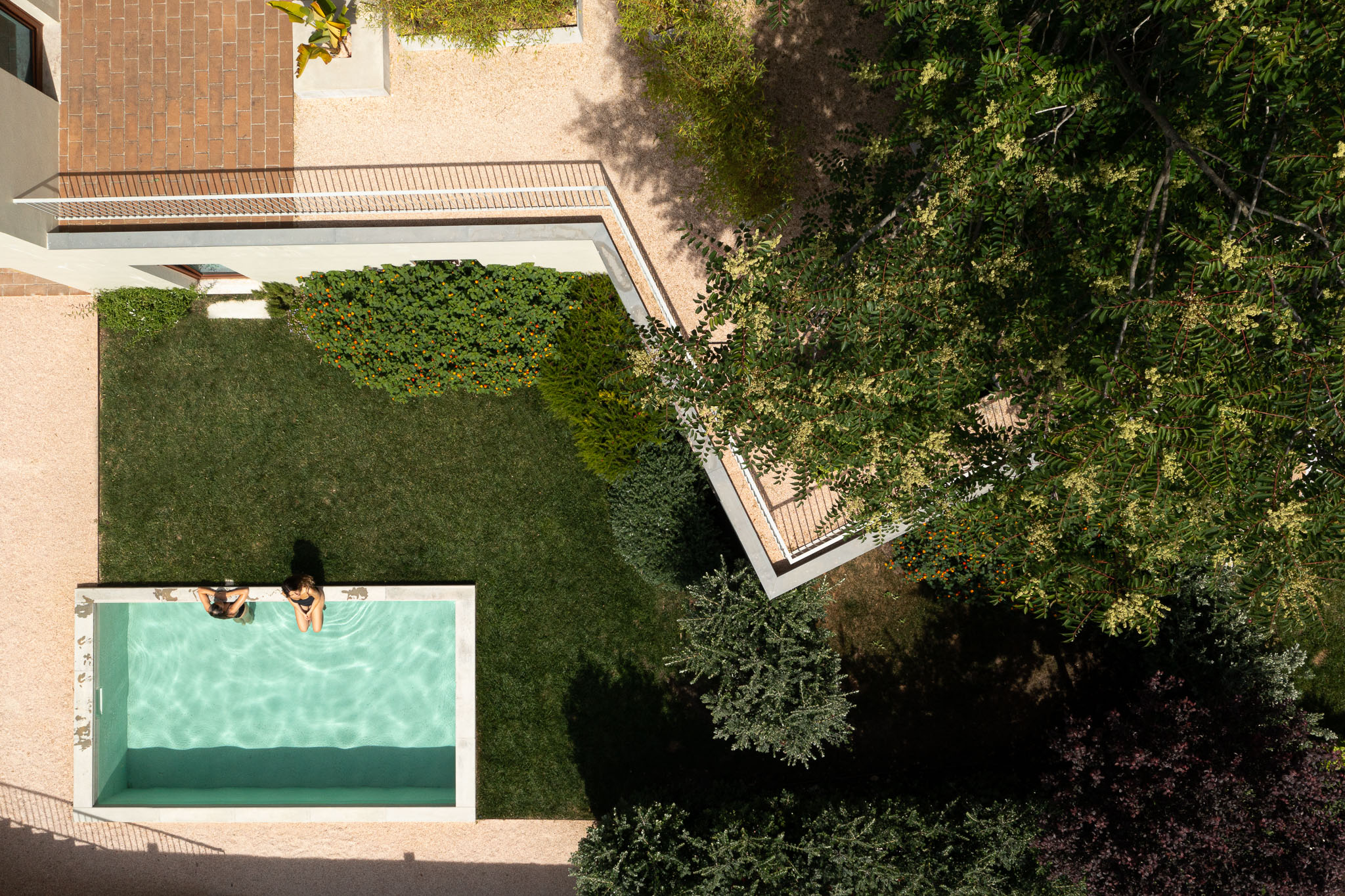 Exterior: Vista aérea do jardim com piscina, relvado, gravilha e vegetação. Arquitetura moderna com linhas retas e varandas. — Prazeres 37 arquitetura Fragmentos em Lisboa