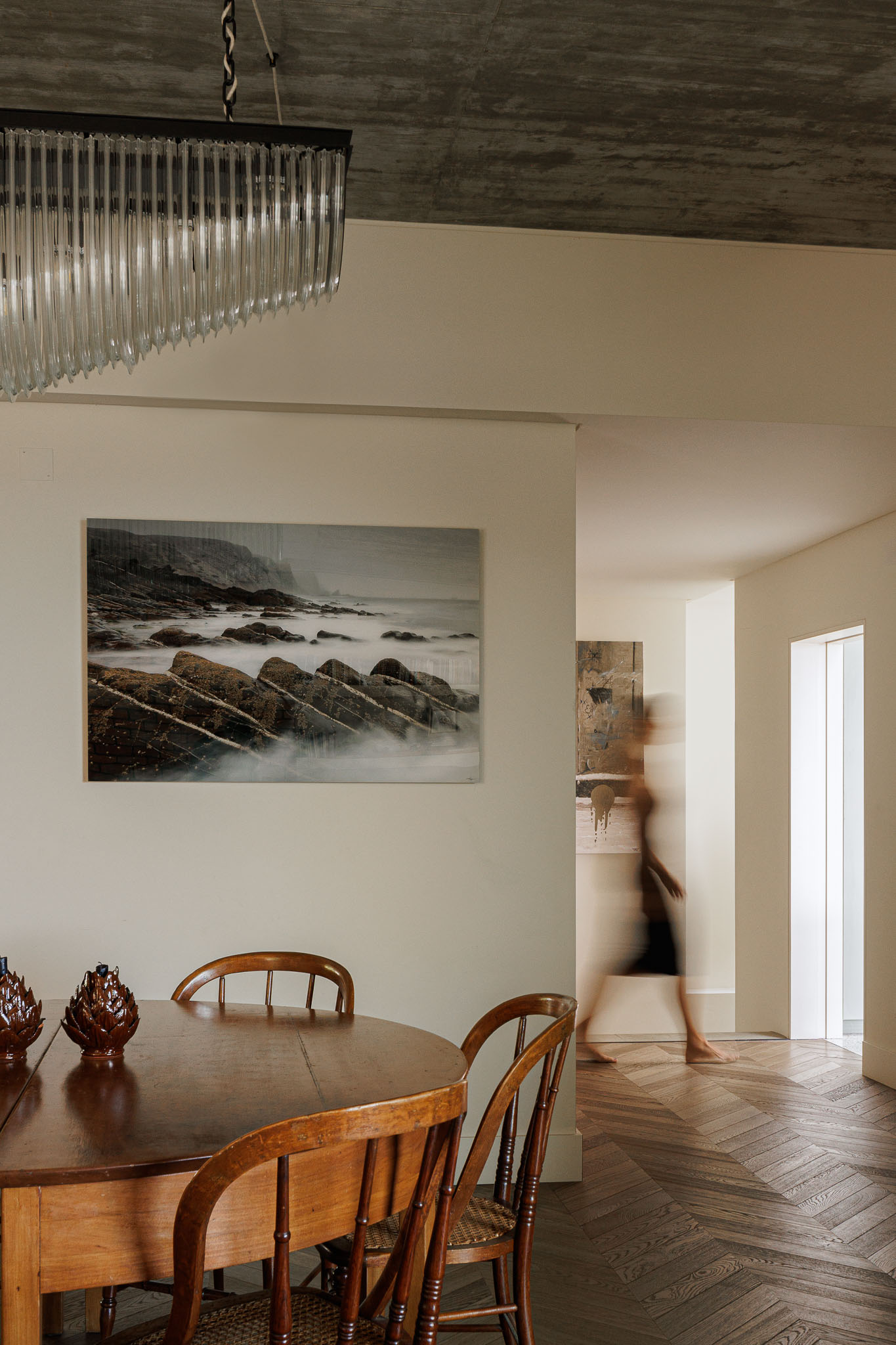 Sala de jantar: Mesa de madeira vintage, cadeiras de palhinha e pavimento em espinha de peixe. Candeeiro moderno e obra de arte. — Prazeres 37 arquitetura Fragmentos em Lisboa