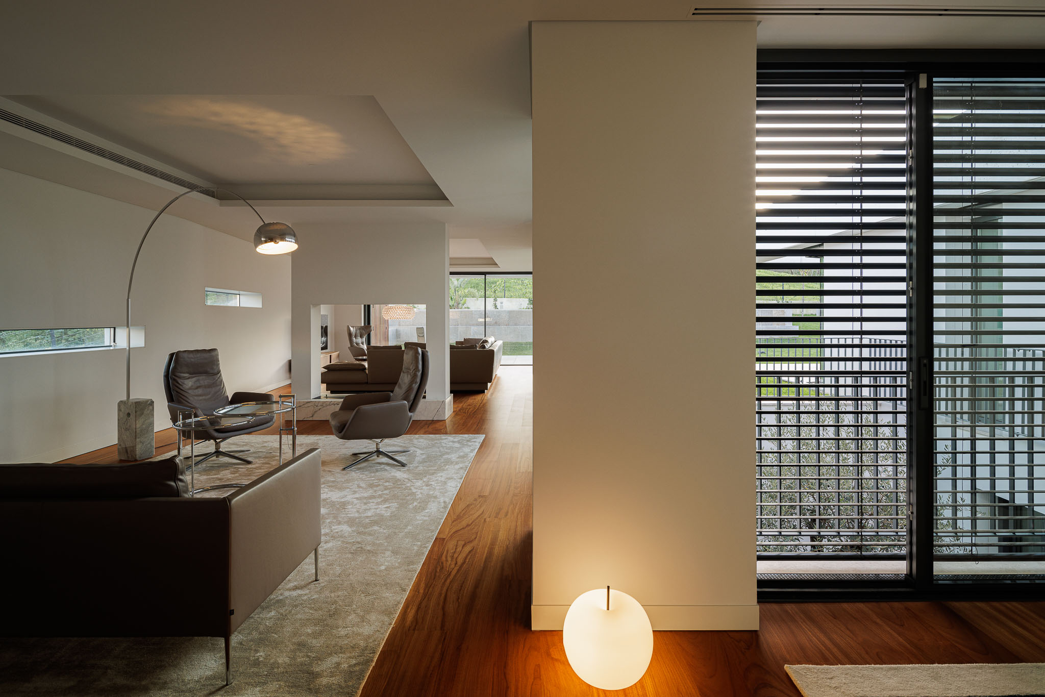 Sala de estar: Vista da sala de estar para a sala de jantar, com sofás, cadeirões e luz natural. — CONCRETE 11 arquitetura Cage Atelier em Lisboa