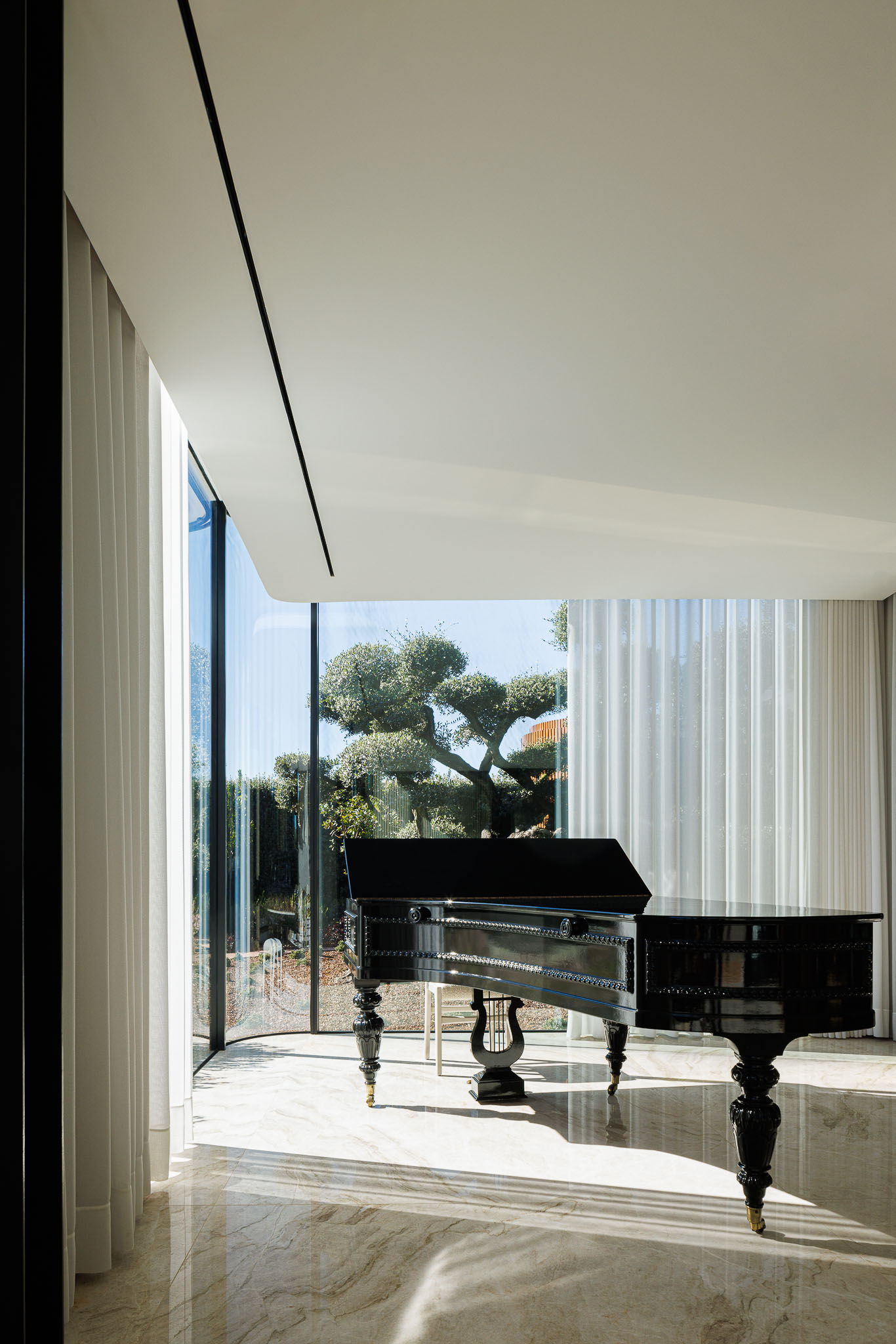 Sala de Música: Piano de cauda preto junto a uma janela panorâmica com cortinas brancas. — Casa de Lavra arquitetura Ricardo Azevedo Arquitecto em Matosinhos