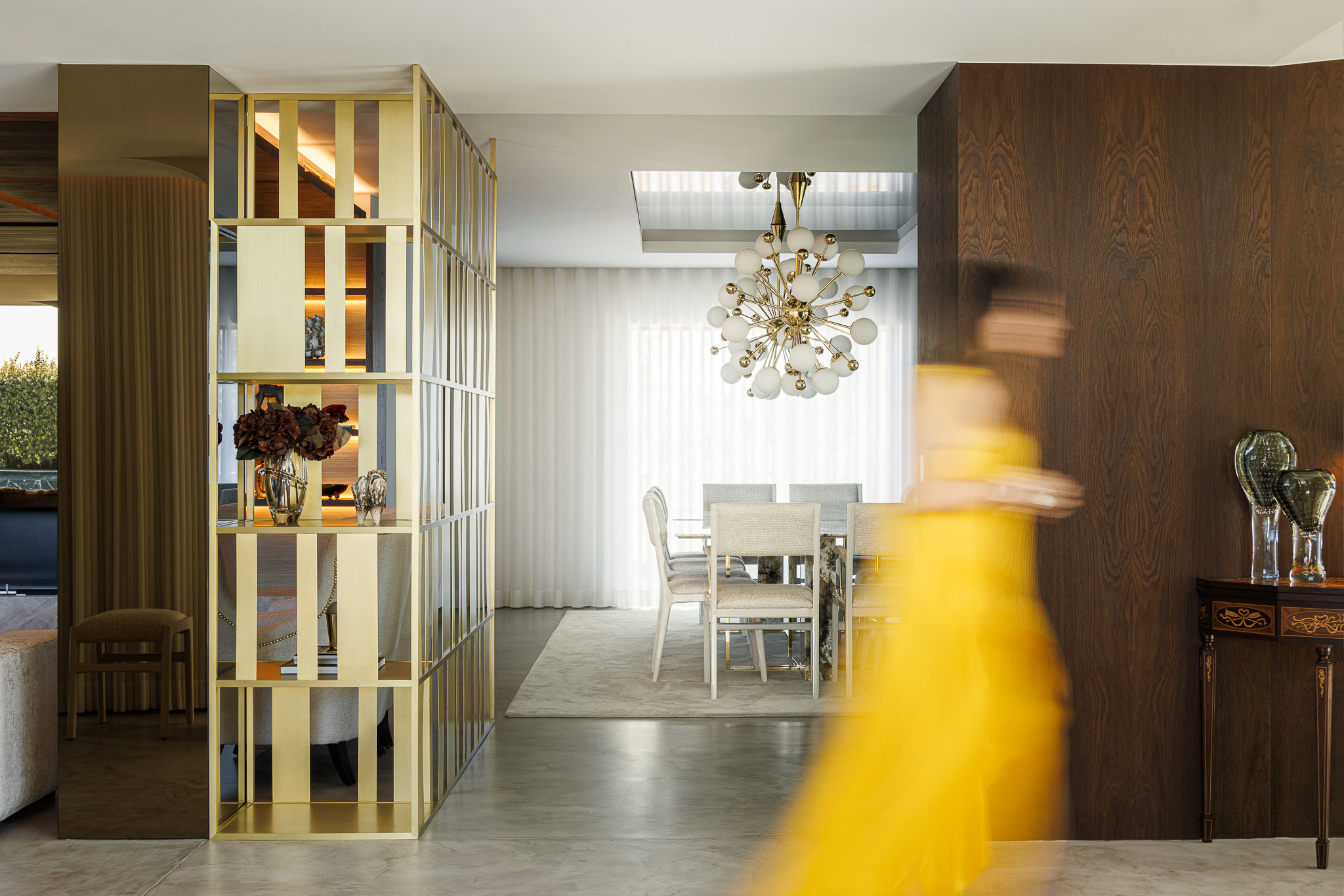 Hall: Divisória dourada entre a sala de estar e jantar, com pavimento em microcimento e mobiliário clássico. — Casa de Lavra arquitetura Ricardo Azevedo Arquitecto em Matosinhos