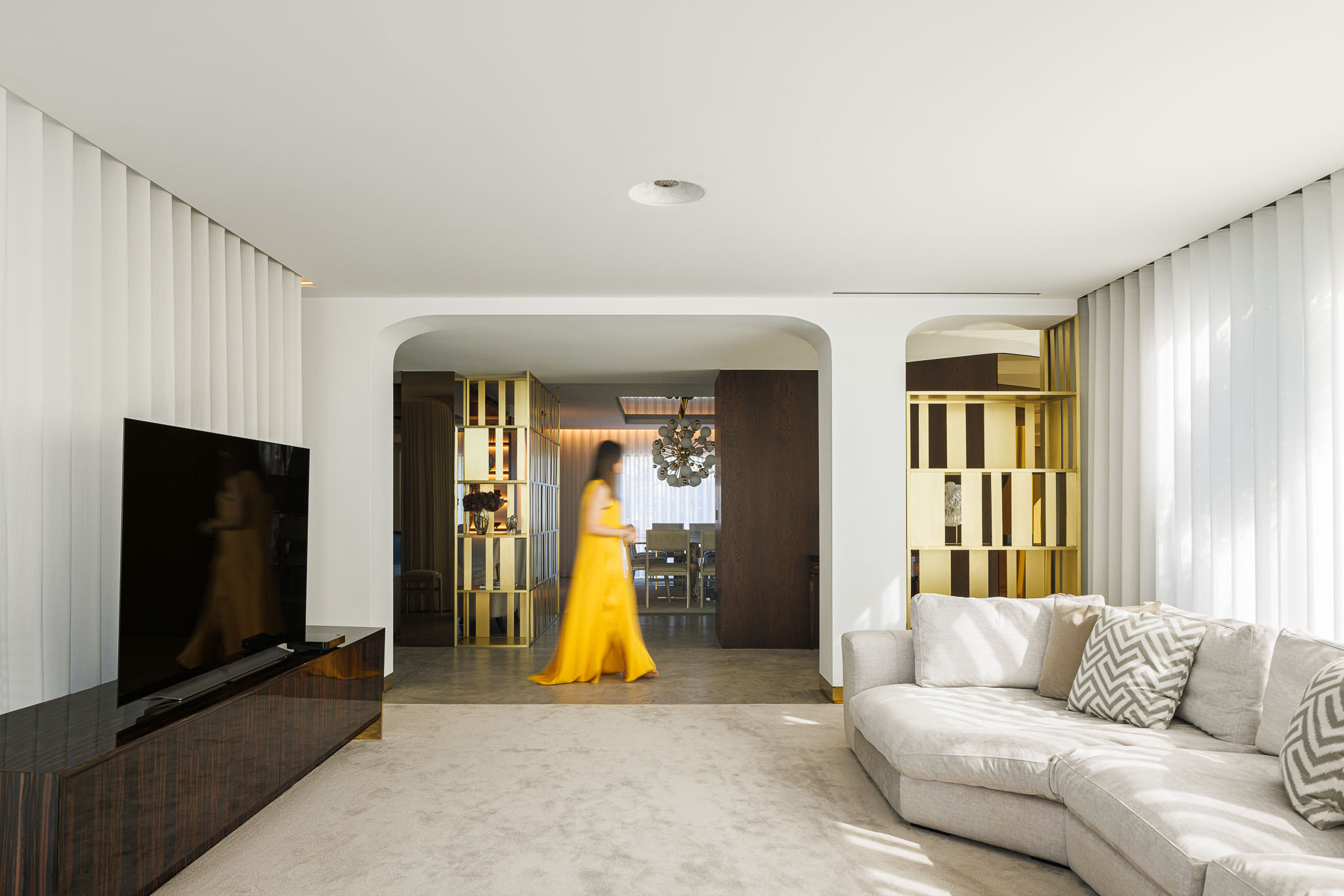 Sala de Estar: Sofá em tons neutros, televisão embutida e divisória para a sala de jantar. — Casa de Lavra arquitetura Ricardo Azevedo Arquitecto em Matosinhos
