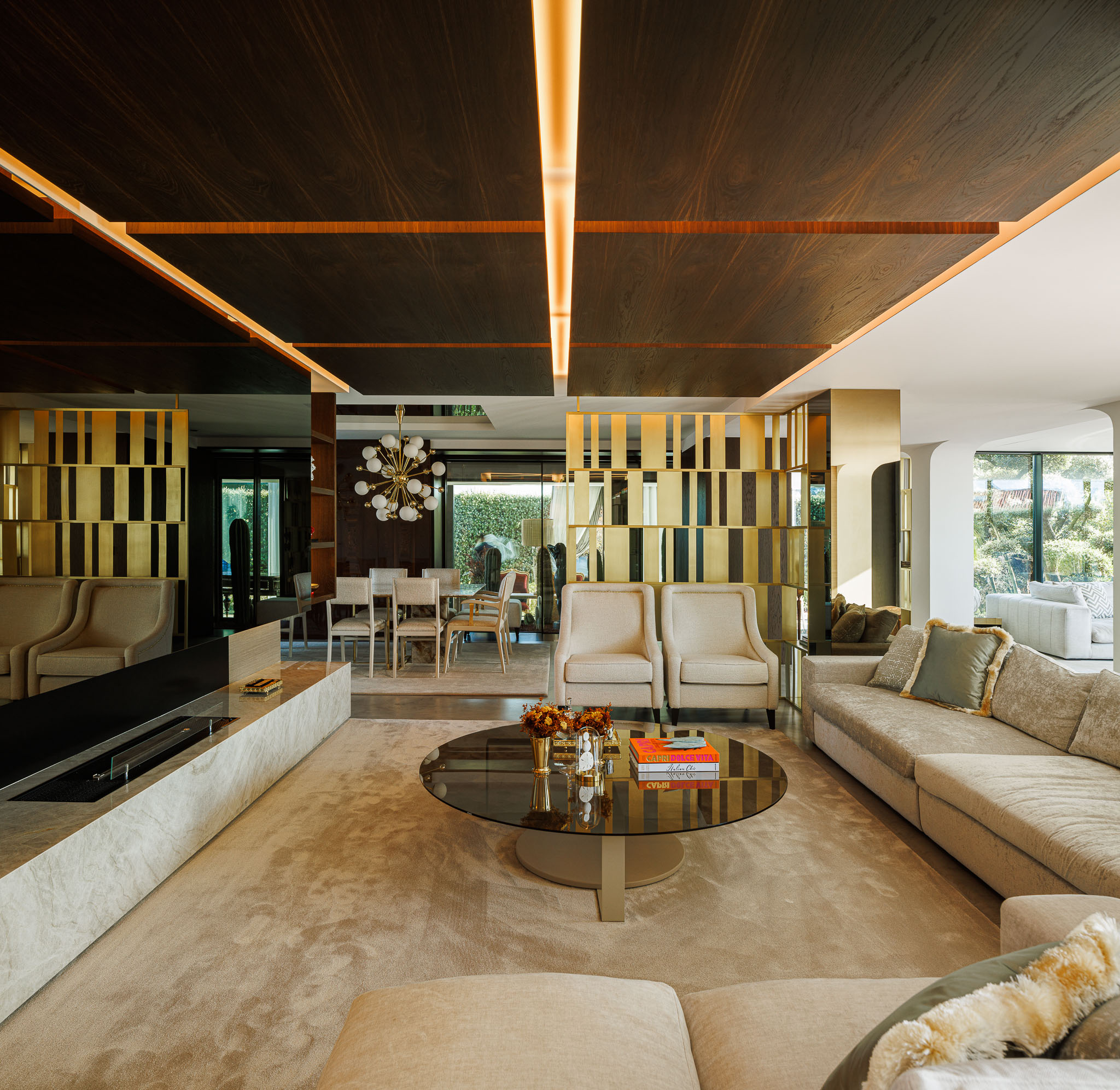 Sala de Estar: Espaço amplo com alcatifa, sofás em tons neutros, divisórias douradas e iluminação indireta. — Casa de Lavra arquitetura Ricardo Azevedo Arquitecto em Matosinhos