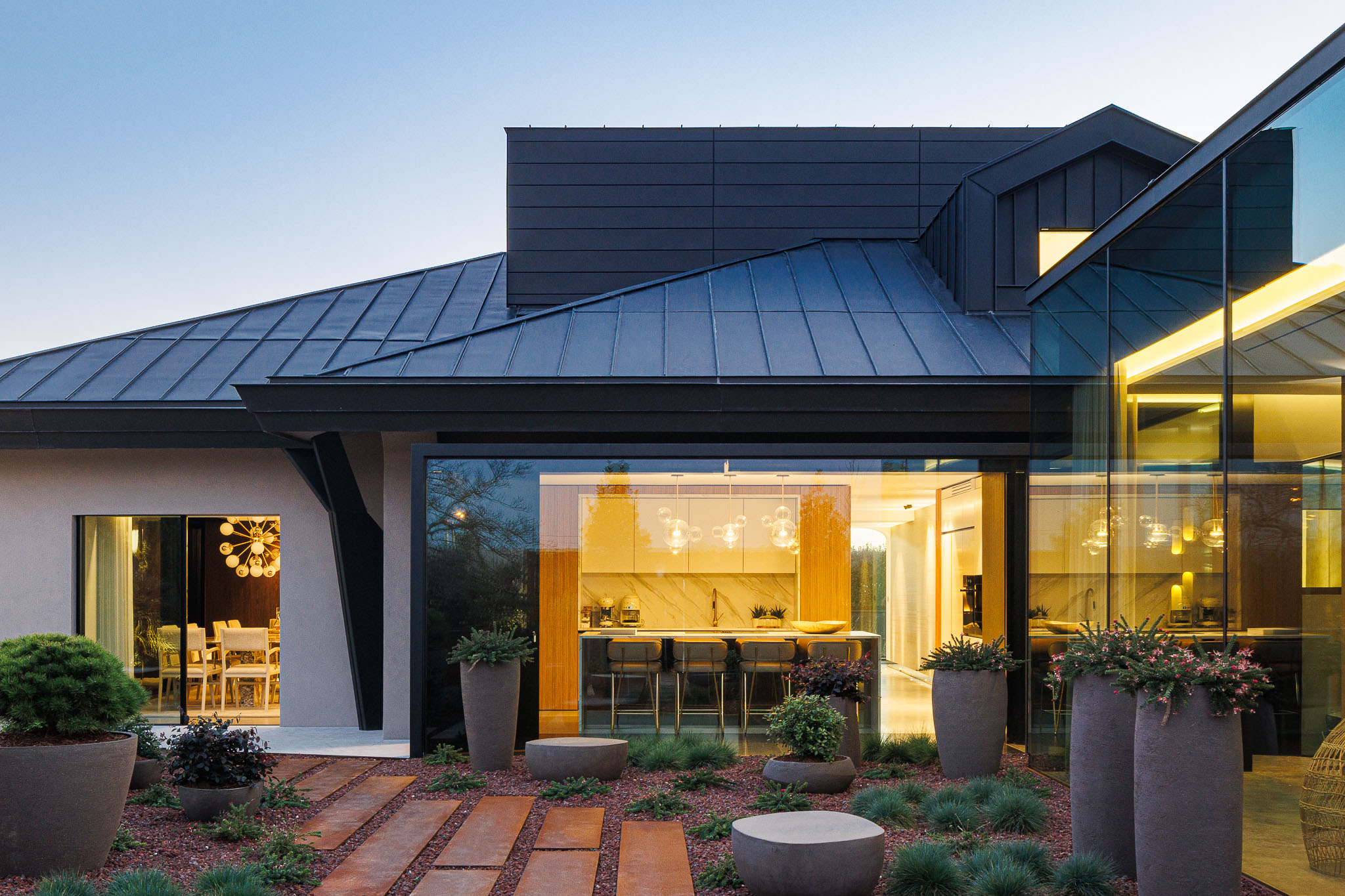 Exterior: Fachada envidraçada da sala de jantar e cozinha com jardim paisagístico. — Casa de Lavra arquitetura Ricardo Azevedo Arquitecto em Matosinhos
