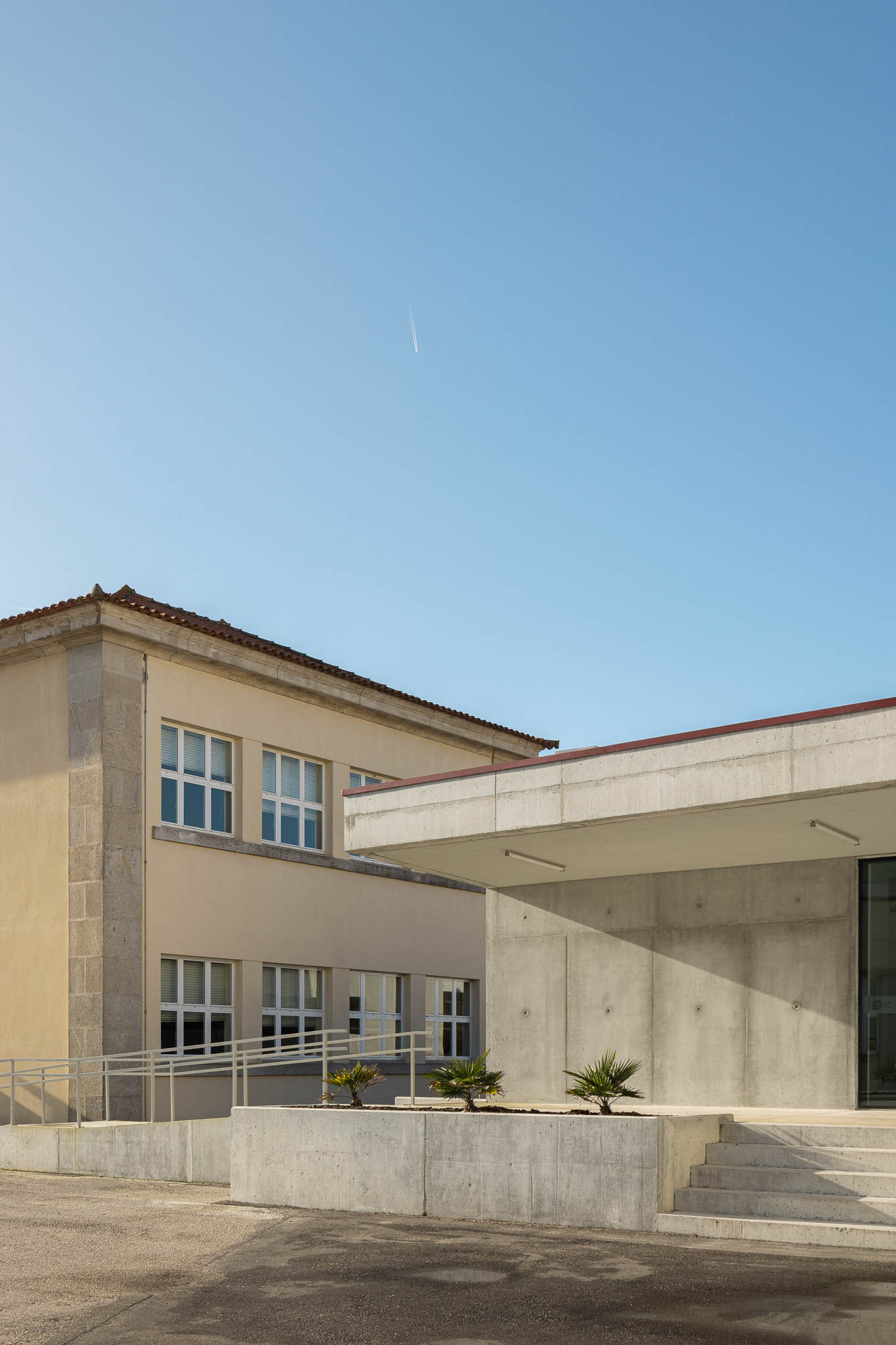 Entrada: Entrada do pavilhão com estrutura em betão aparente e escadas. — Pavilhão Desportivo da Escola Secundária Eça de Queirós arquitetura Oval em Póvoa de Varzim