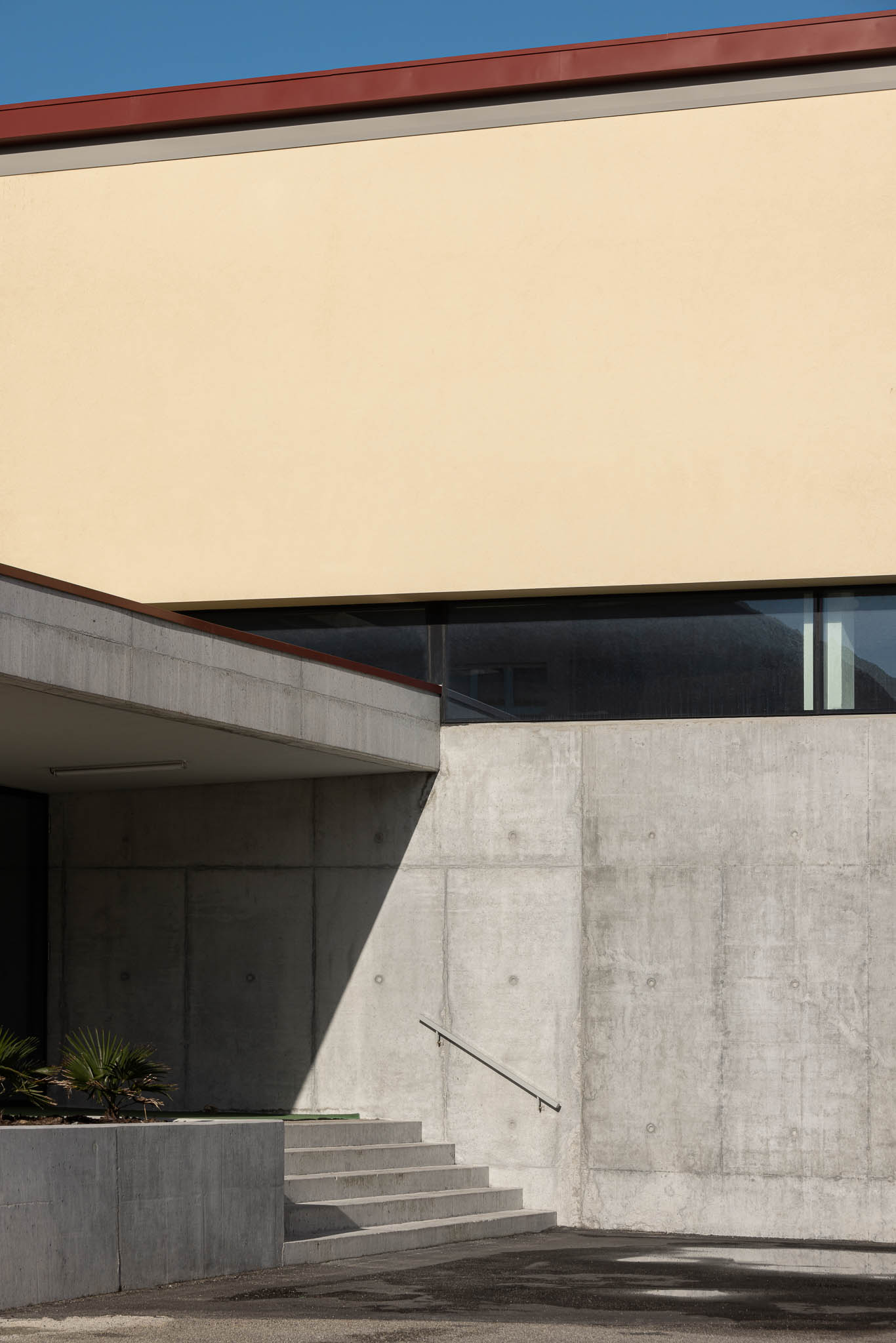 Entrada: Detalhe da entrada com paredes em betão, escadas e corrimão metálico. — Pavilhão Desportivo da Escola Secundária Eça de Queirós arquitetura Oval em Póvoa de Varzim