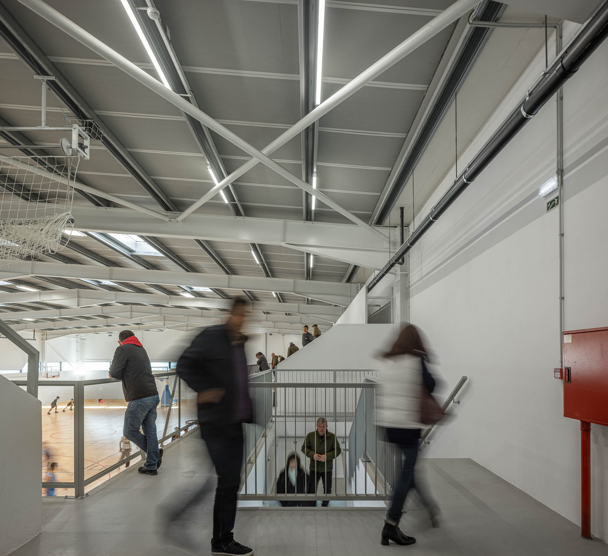 Bancada: Vista da bancada superior para o pavilhão, estrutura metálica no teto. — Pavilhão Desportivo da Escola Secundária Eça de Queirós arquitetura Oval em Póvoa de Varzim