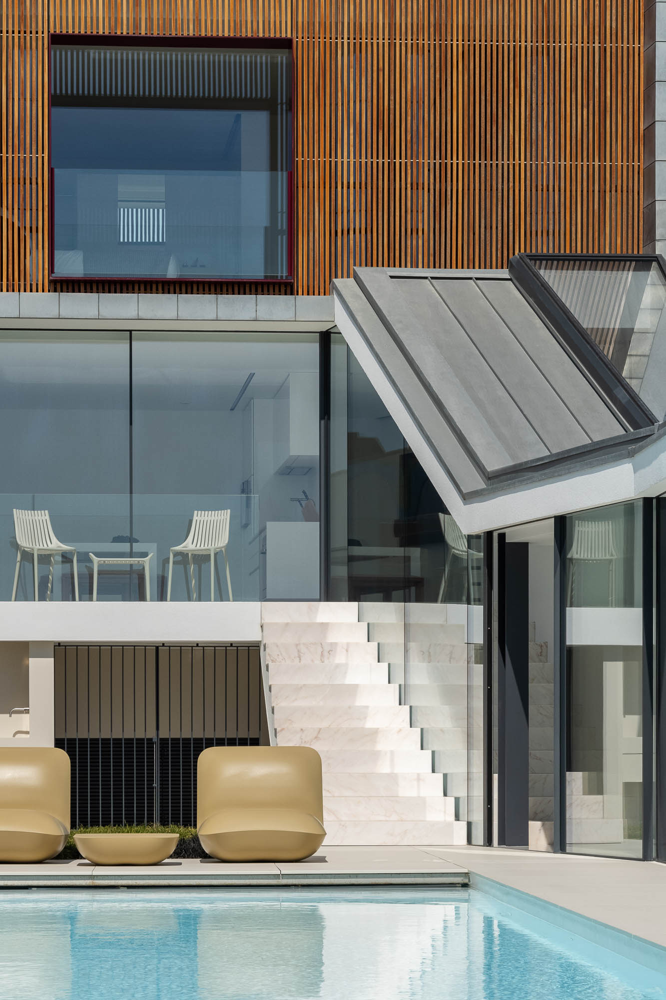 Exterior: Piscina com espreguiçadeiras, escadas em mármore e vista para a casa com revestimento em madeira. Design moderno e elegante. — Casa Costa Nova arquitetura Espaço Objecto em Ílhavo
