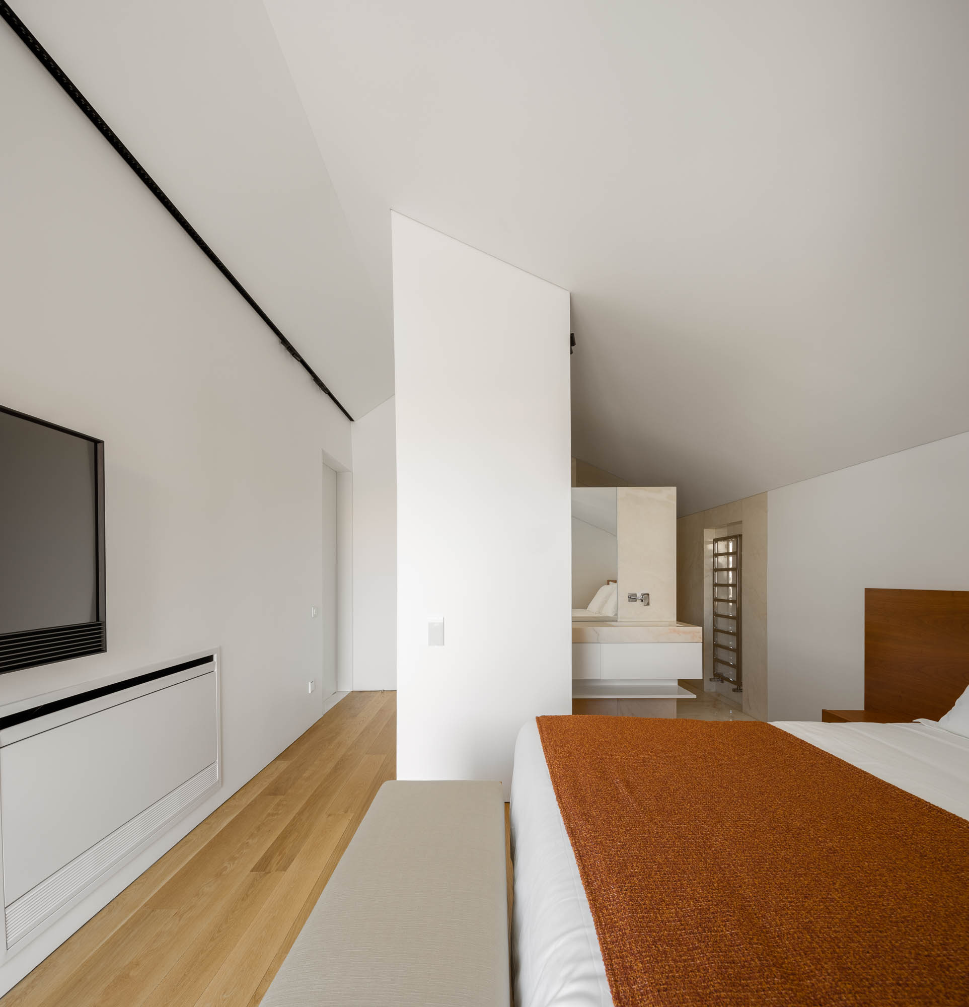 Quarto: Cama com roupa de cama laranja, casa de banho integrada com lavatório em mármore e janela com vista. Design moderno. — Casa Costa Nova arquitetura Espaço Objecto em Ílhavo