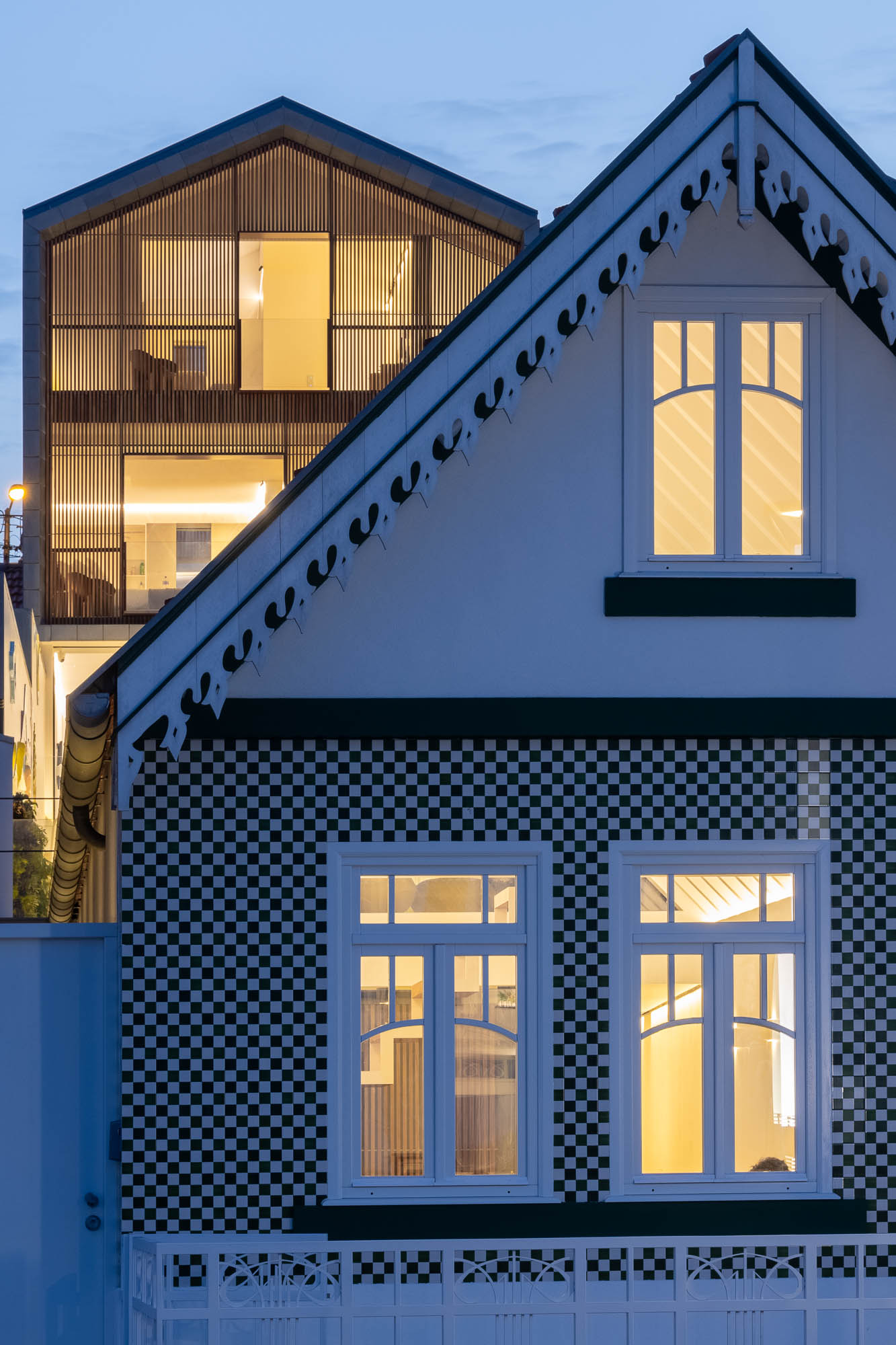 Exterior: Fachada da casa com revestimento em madeira, porta de garagem vermelha e design moderno. Arquitetura contemporânea. — Casa Costa Nova arquitetura Espaço Objecto em Ílhavo