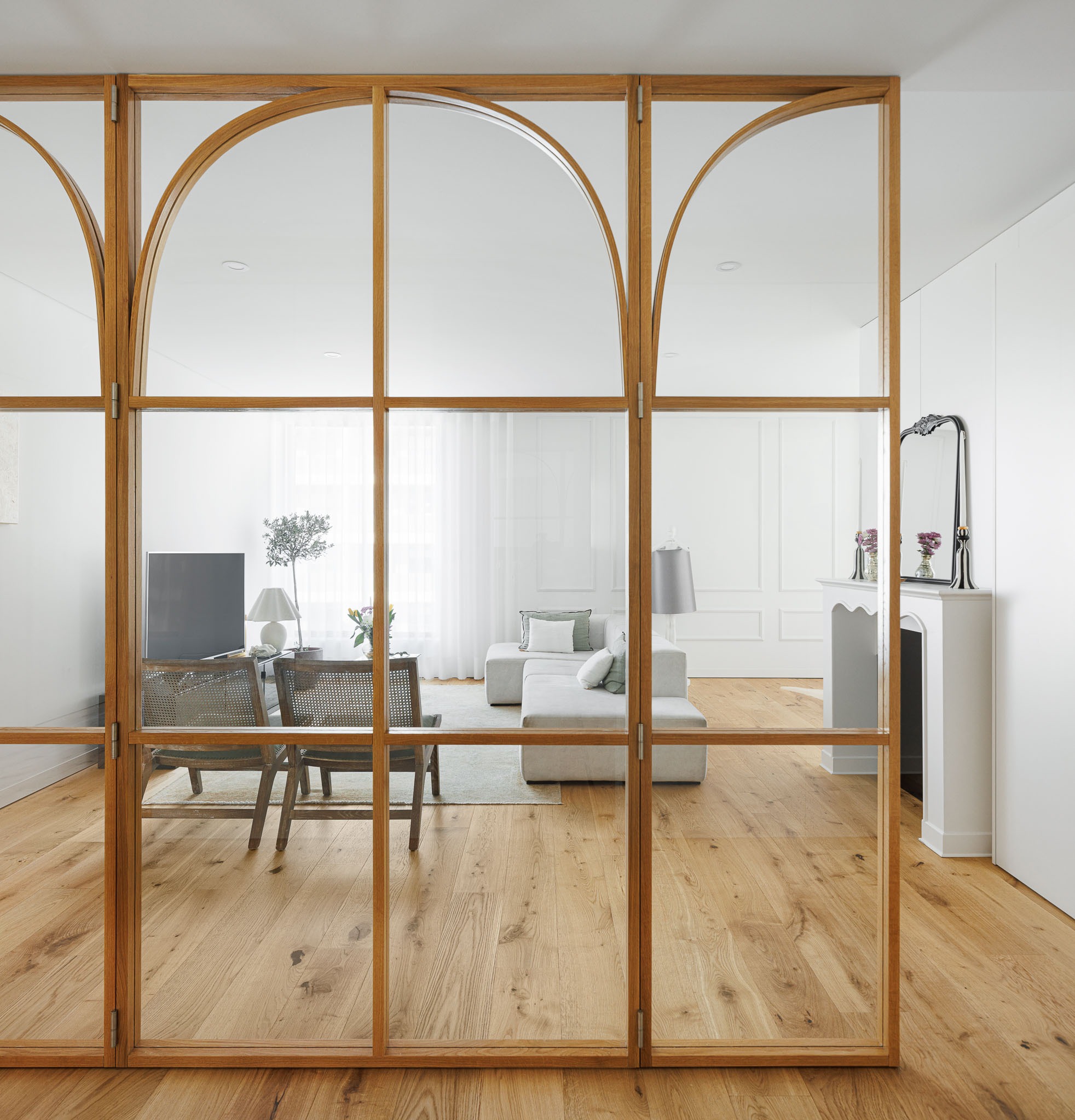 Sala de estar: Divisória em vidro e madeira que separa a sala de estar do corredor, com cadeiras de vime. — 5ª Avenida arquitetura Mário Alves Arquitecto em Aveiro