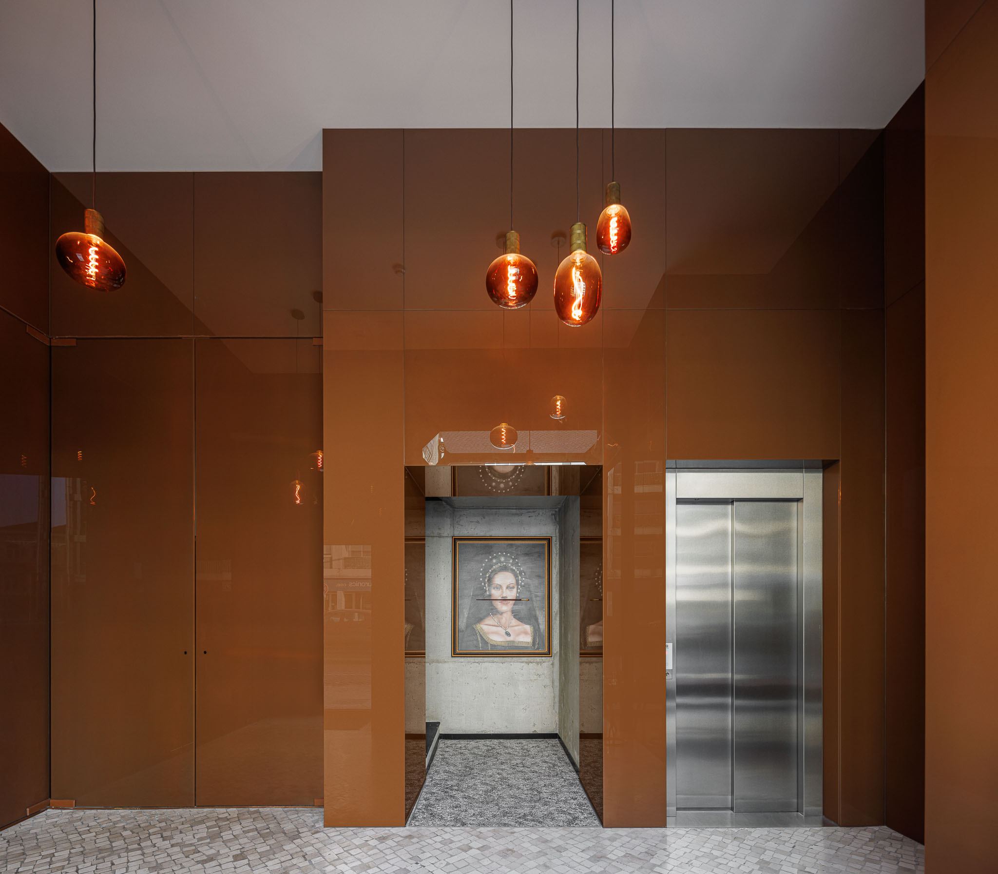 Hall de entrada: Detalhe do hall com paredes espelhadas em bronze, elevador e quadros clássicos. — 5ª Avenida arquitetura Mário Alves Arquitecto em Aveiro