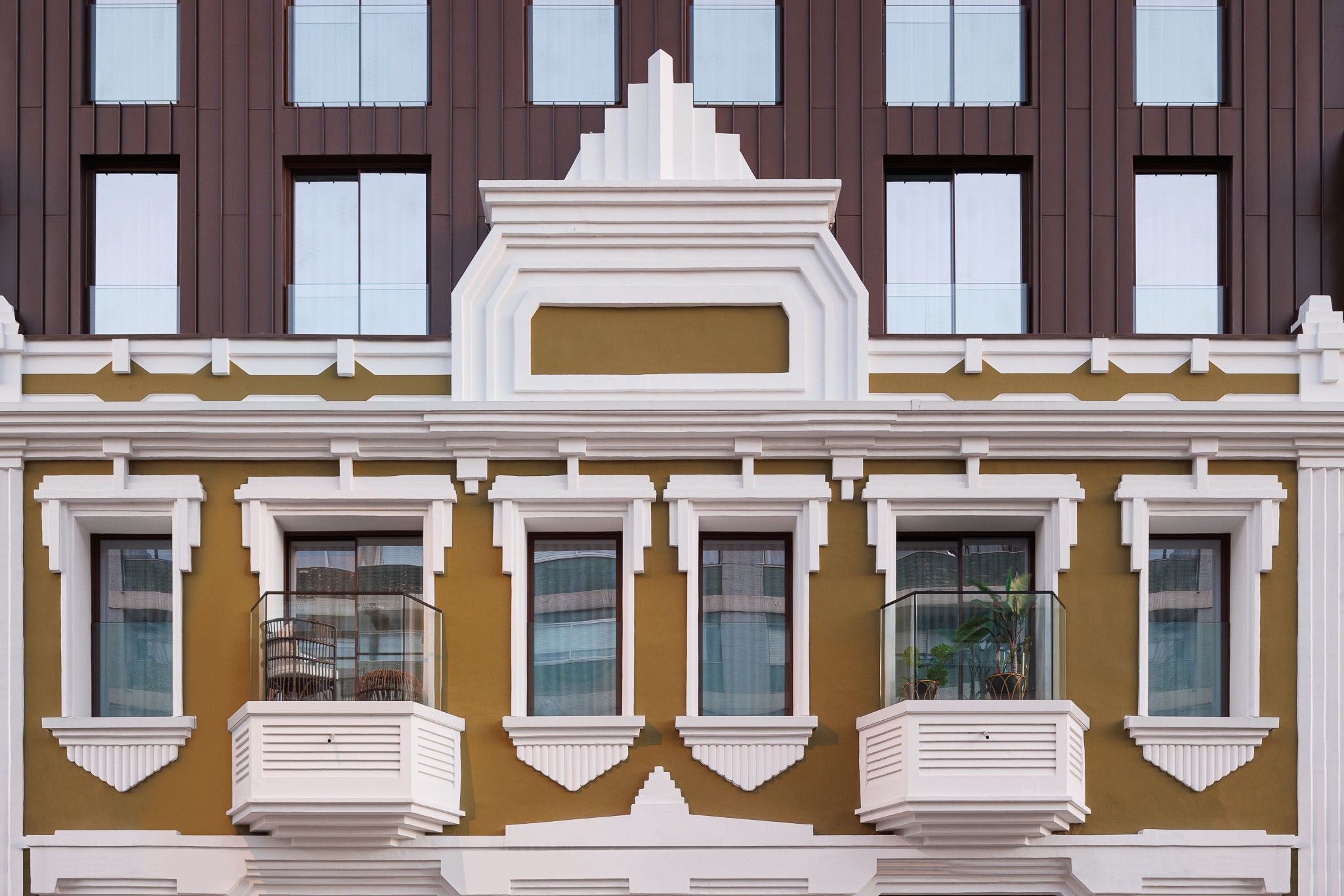 Fachada: Detalhe da fachada histórica renovada, com janelas e varandas em tons de verde e branco. — 5ª Avenida arquitetura Mário Alves Arquitecto em Aveiro