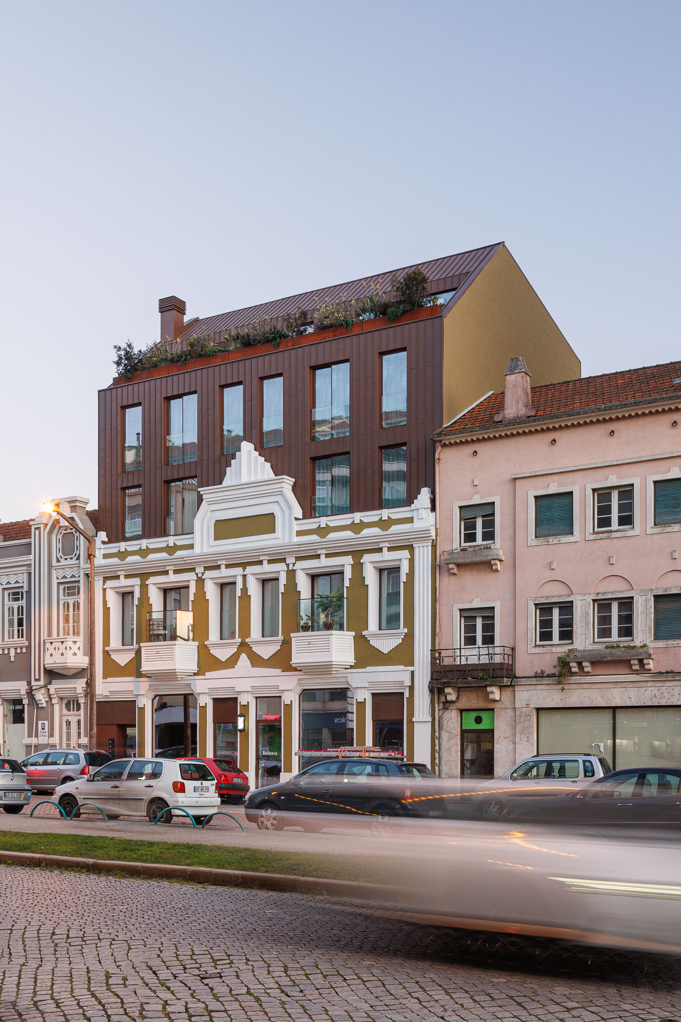 Fachada: Edifício renovado integrado na rua, com fachada histórica e adição moderna em cobre. — 5ª Avenida arquitetura Mário Alves Arquitecto em Aveiro