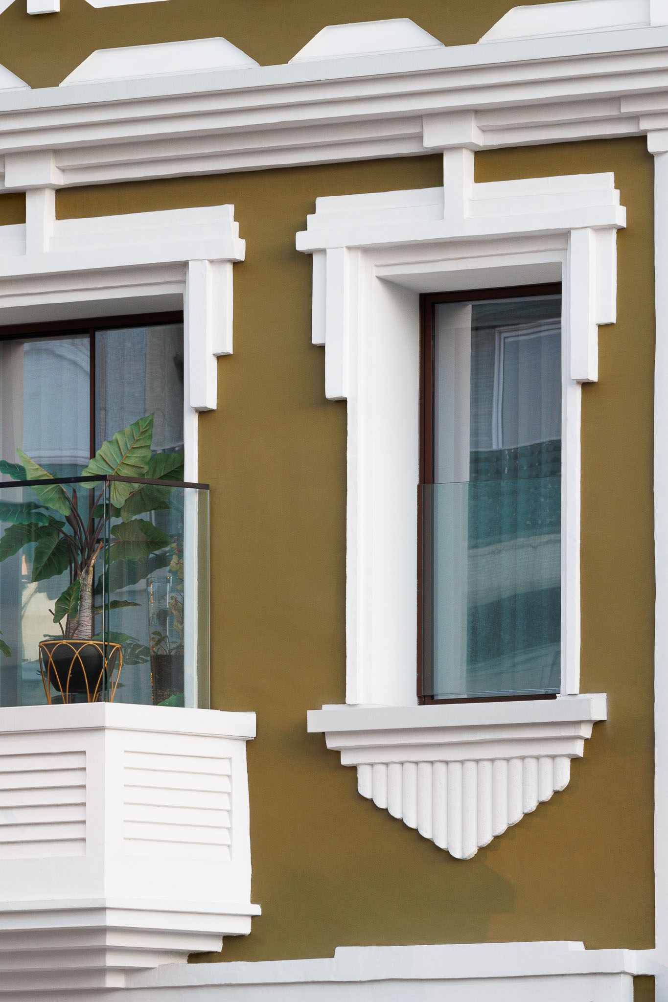 Fachada: Detalhe da fachada histórica renovada, com janelas e varandas com plantas. — 5ª Avenida arquitetura Mário Alves Arquitecto em Aveiro