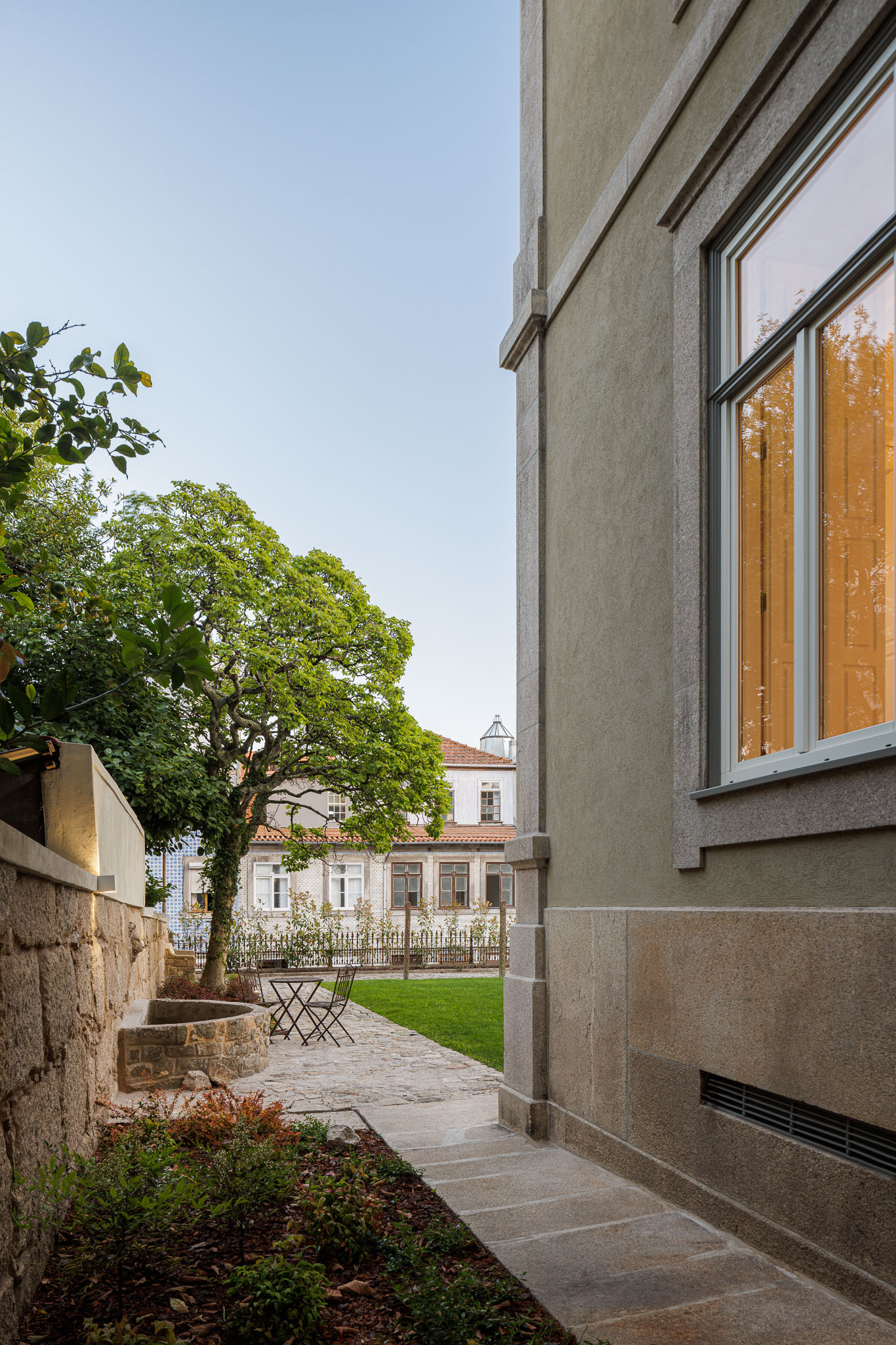 Exterior: Caminho de pedra, jardim relvado e fachada lateral da casa. — Casa Kala arquitetura Ren Ito em Porto
