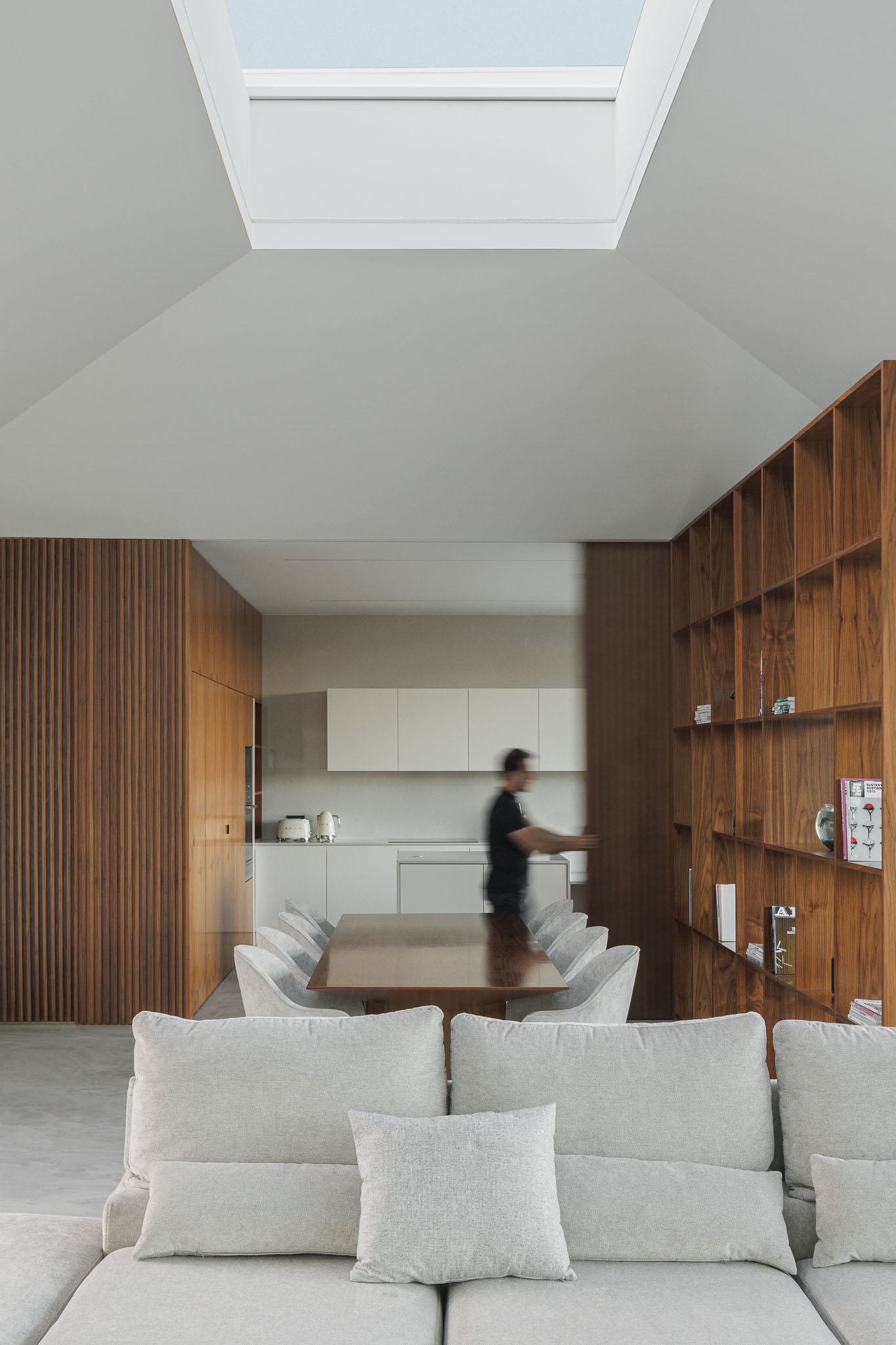 Sala de jantar: Vista da sala de jantar para a cozinha, com divisória em madeira e estante. — Casa Ponte arquitetura stu.dere em Amarante