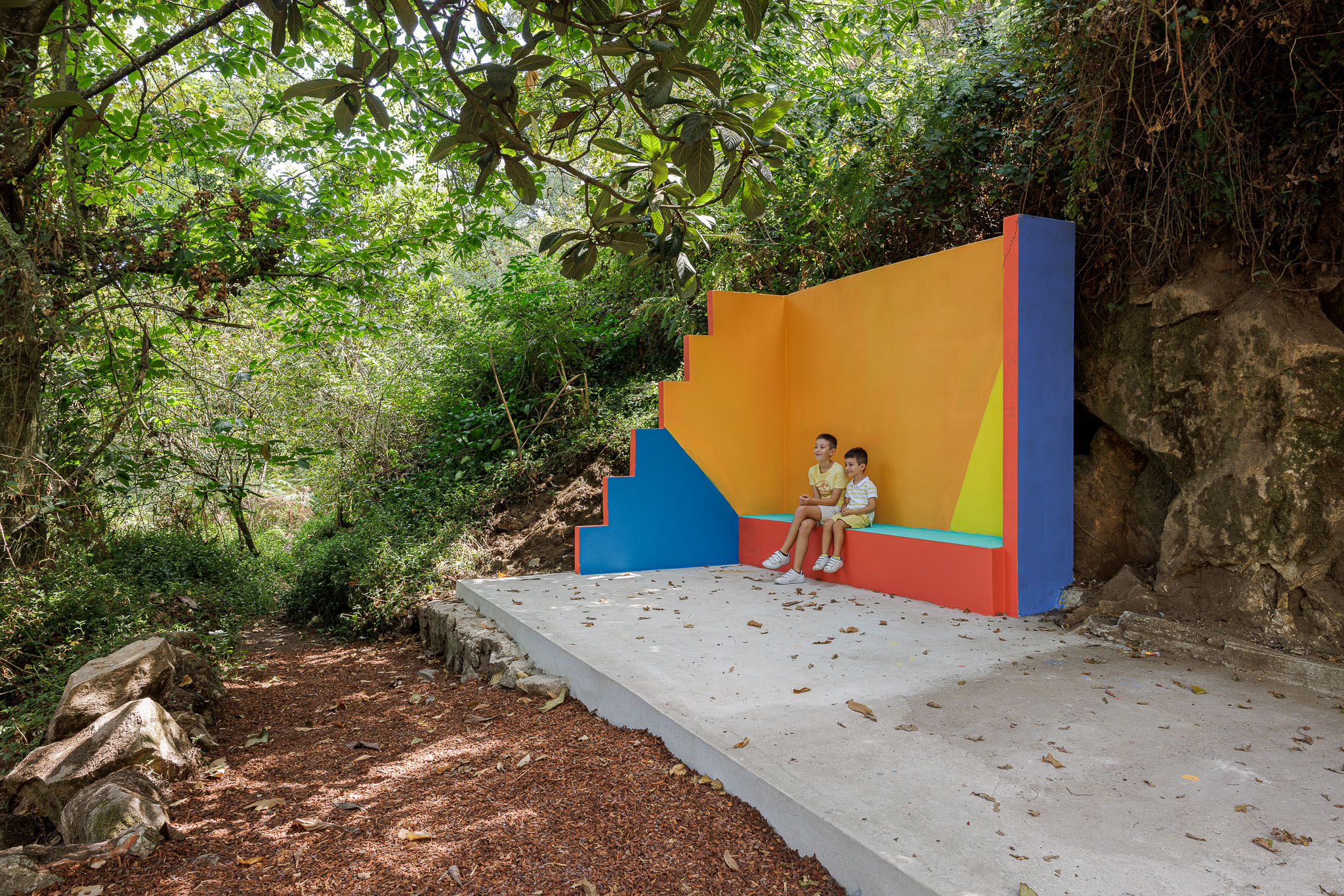 Espaço de lazer: Parede colorida com escadas e banco em betão pintado, num parque arborizado. — Caminho das Escadinhas arquitetura Paulo Moreira Architectures e verkron em Matosinhos