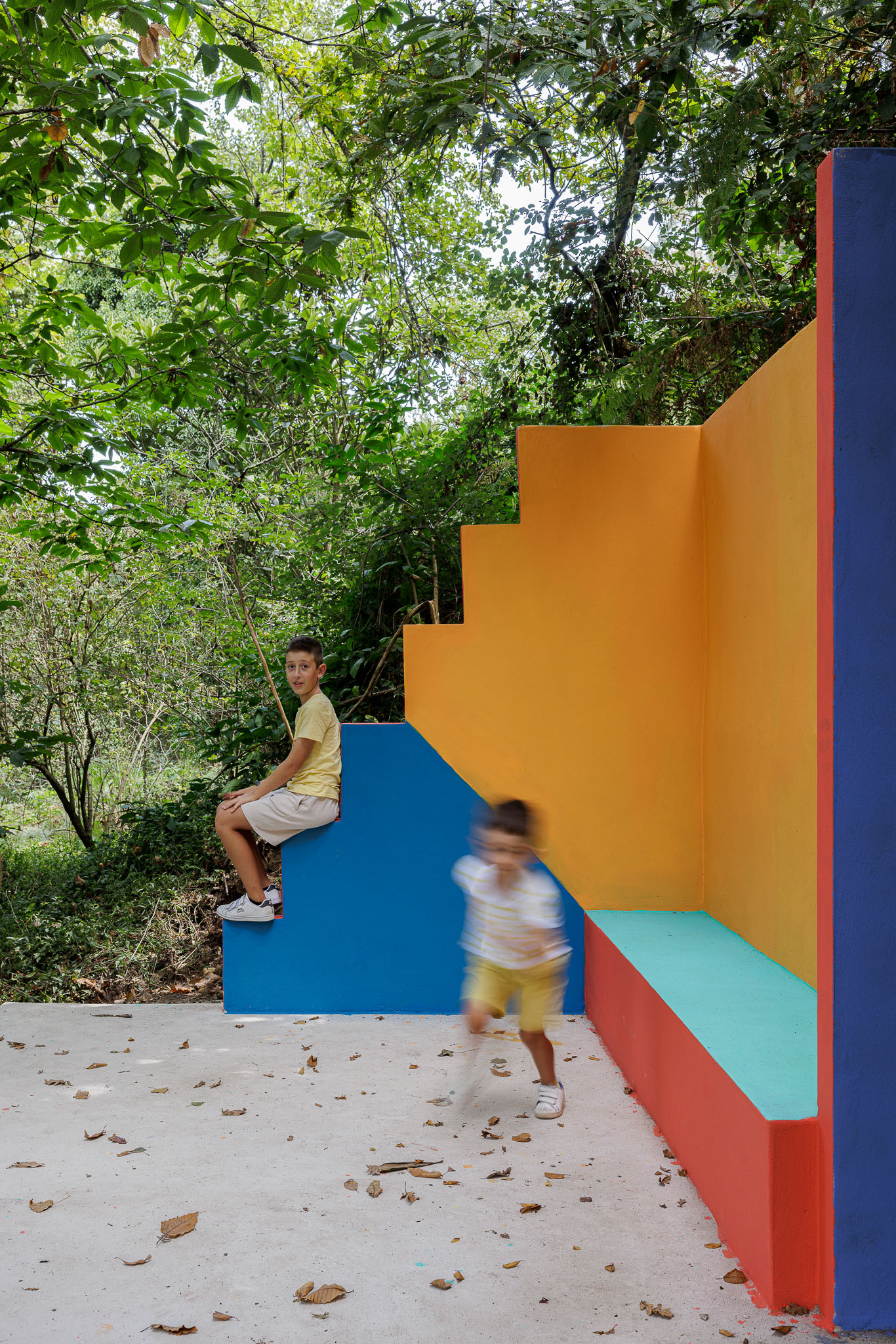 Espaço de lazer: Detalhe da parede colorida com escadas e banco em betão pintado, num parque arborizado. — Caminho das Escadinhas arquitetura Paulo Moreira Architectures e verkron em Matosinhos