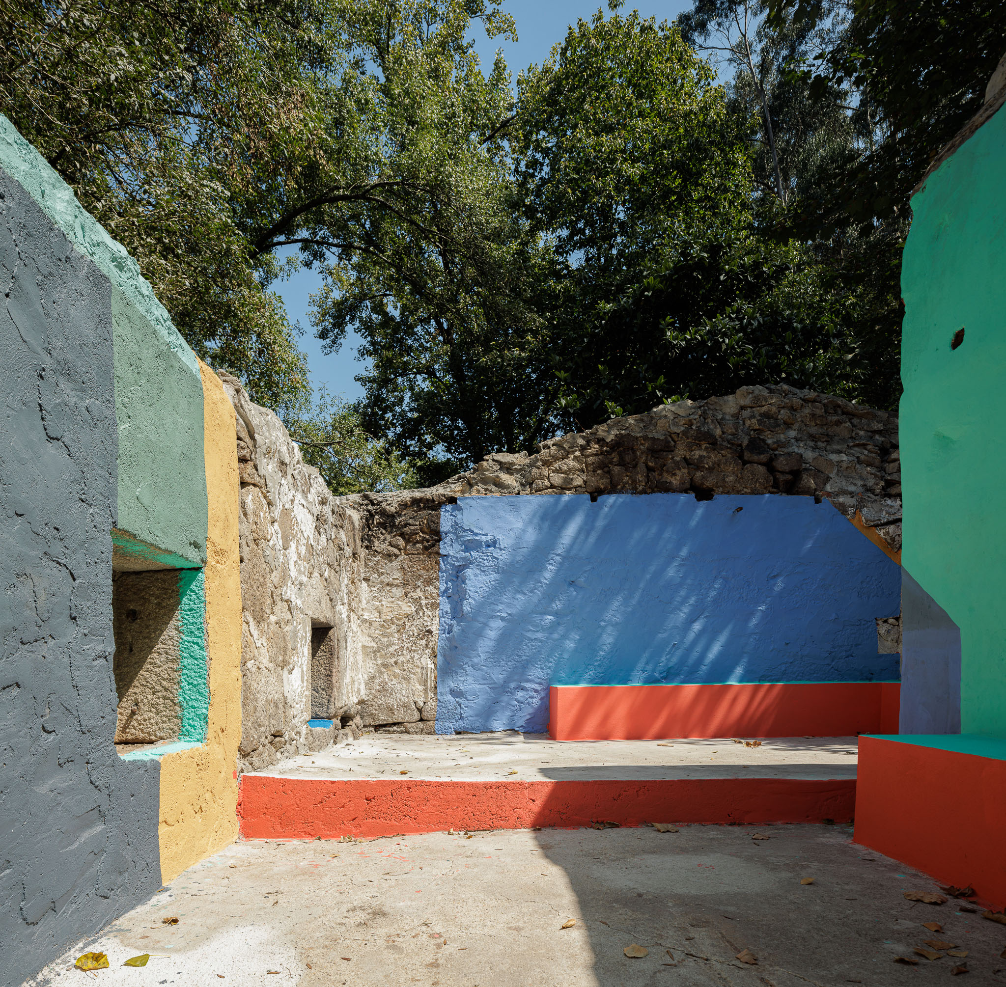 Espaço de lazer: Interior de estrutura colorida em betão pintado, com ruínas de pedra. — Caminho das Escadinhas arquitetura Paulo Moreira Architectures e verkron em Matosinhos