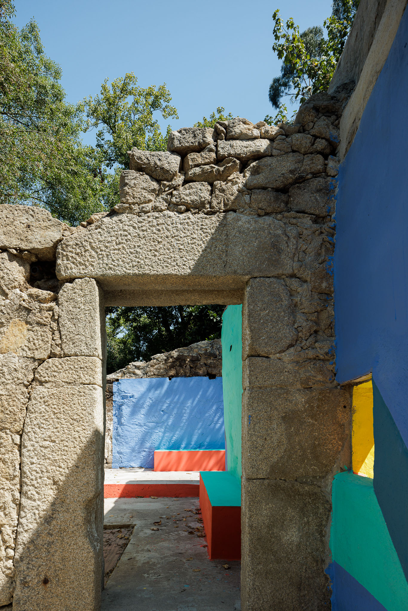 Espaço de lazer: Ruínas de pedra com porta e paredes coloridas em betão pintado. — Caminho das Escadinhas arquitetura Paulo Moreira Architectures e verkron em Matosinhos