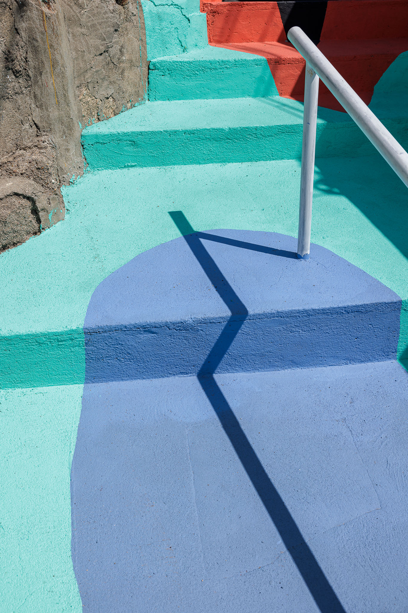 Escadaria: Degraus coloridos em betão pintado, com corrimão metálico branco. — Caminho das Escadinhas arquitetura Paulo Moreira Architectures e verkron em Matosinhos