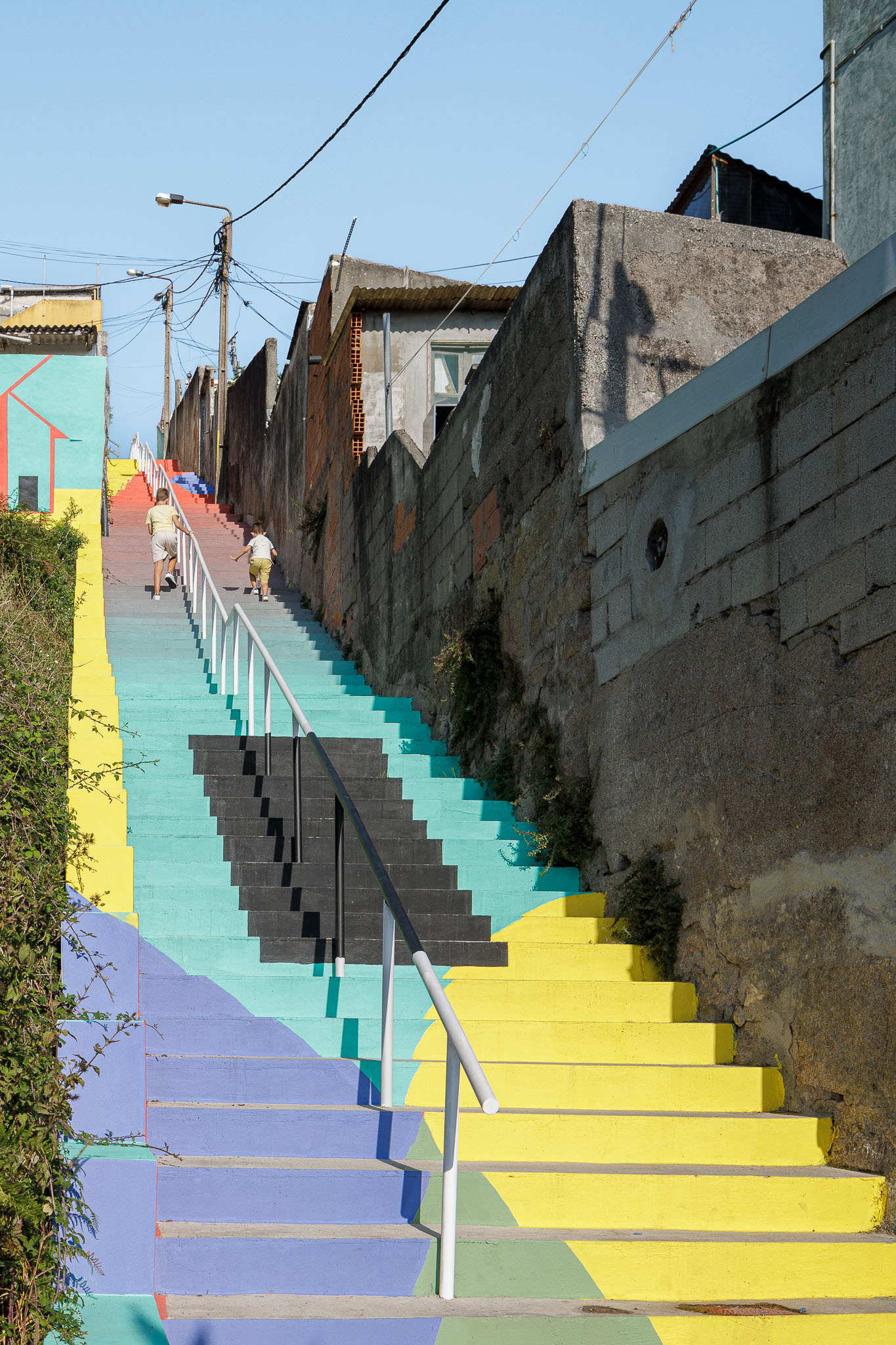 Escadaria: Longa escadaria colorida em betão pintado, com corrimão metálico branco. — Caminho das Escadinhas arquitetura Paulo Moreira Architectures e verkron em Matosinhos