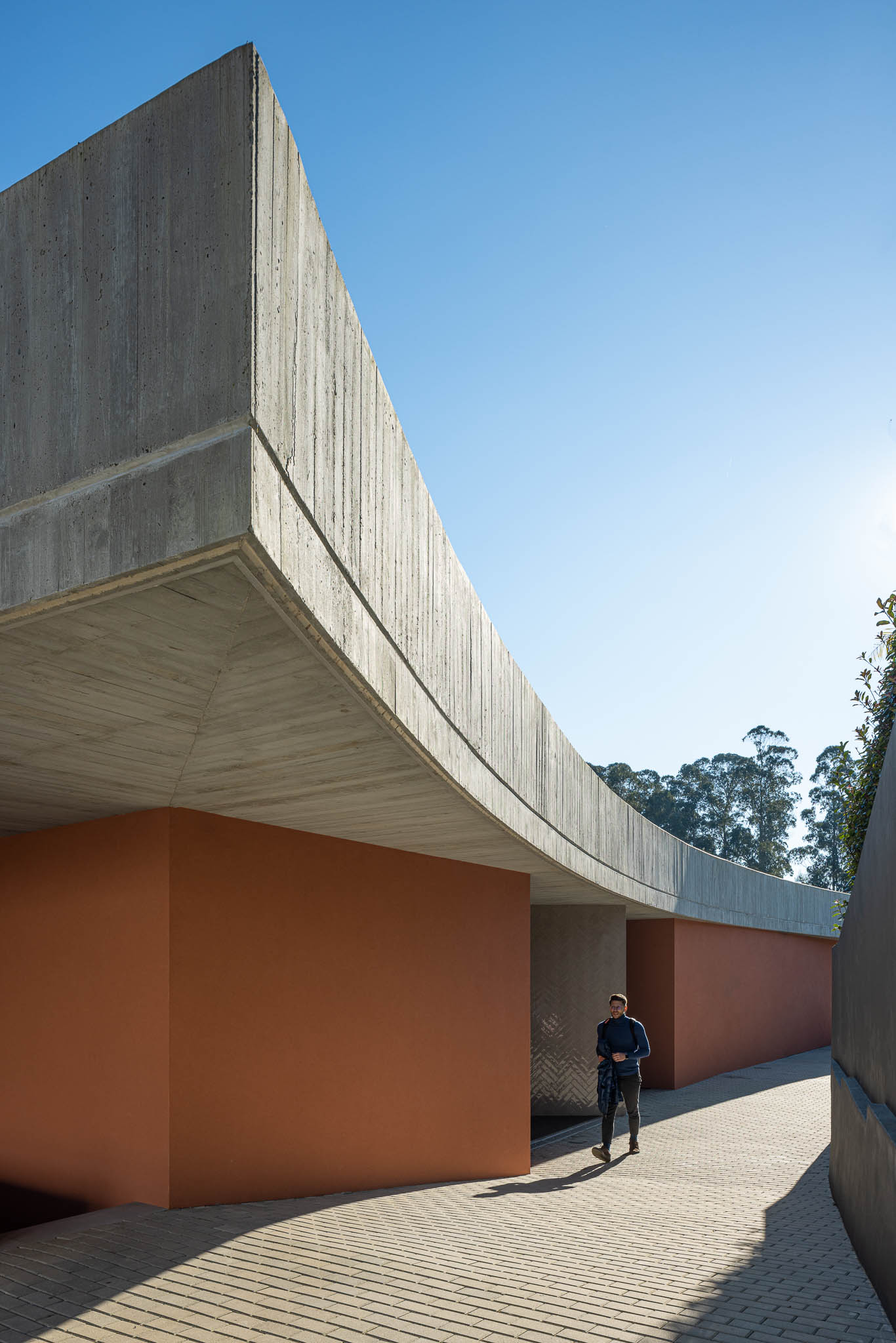 Exterior: Varanda com laje de betão aparente e paredes cor de tijolo. — TM House arquitetura Inception Architects Studio em Santo Tirso