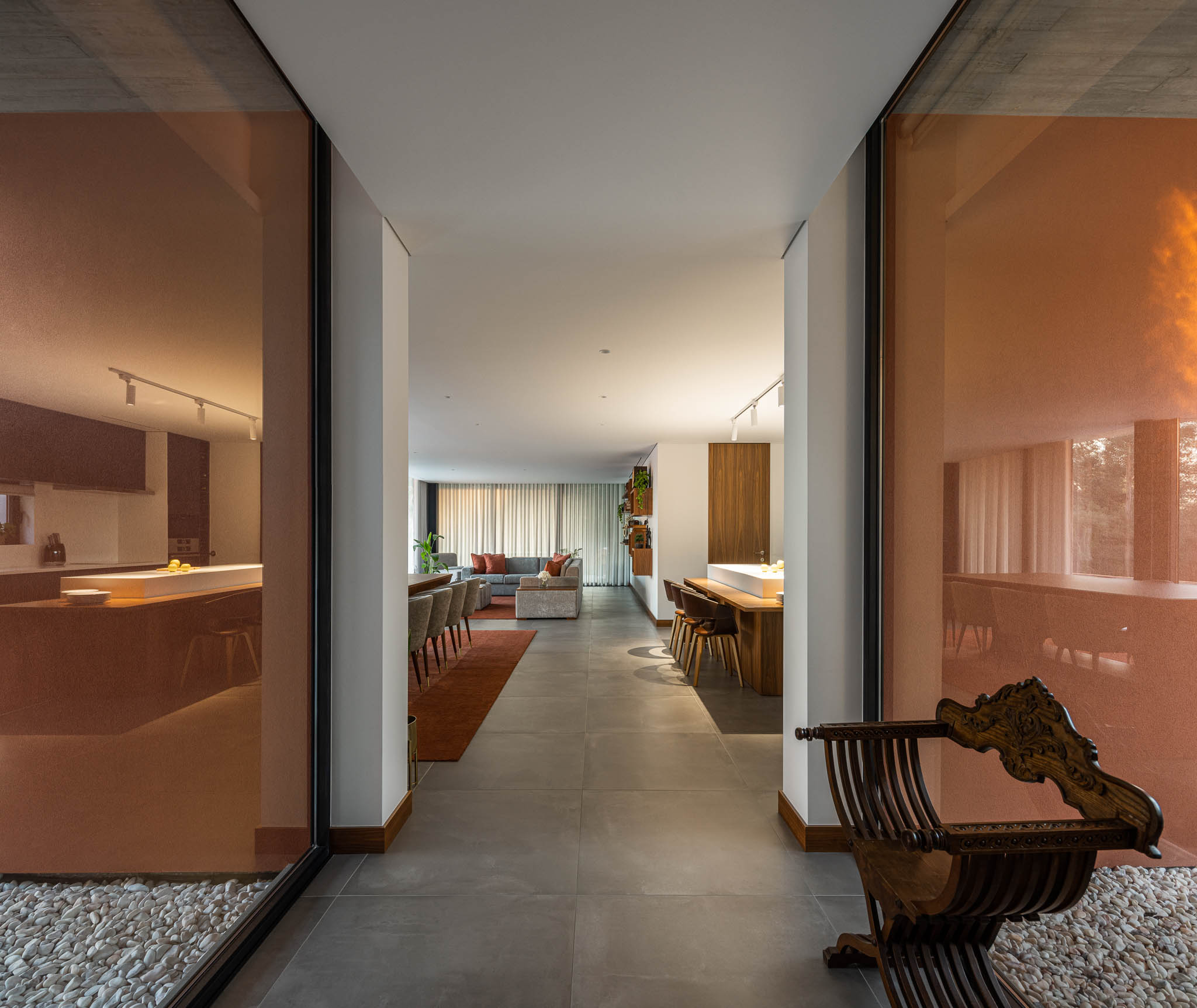 Interior: Vista para a cozinha, sala de jantar e sala de estar a partir do pátio interior. — TM House arquitetura Inception Architects Studio em Santo Tirso