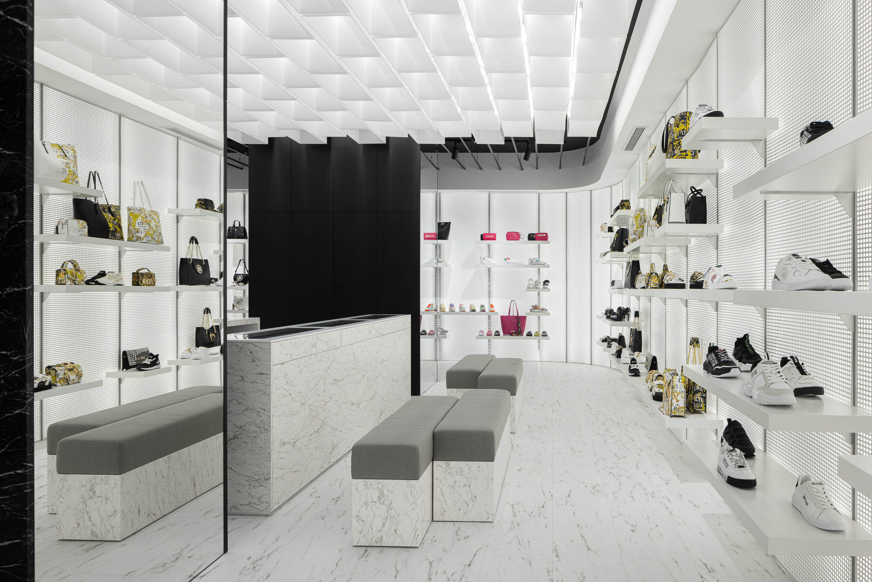 Loja: Vista geral do interior com bancos, balcão em mármore e prateleiras iluminadas. — Walk With Me Store arquitetura REM'A Arquitectos em Porto