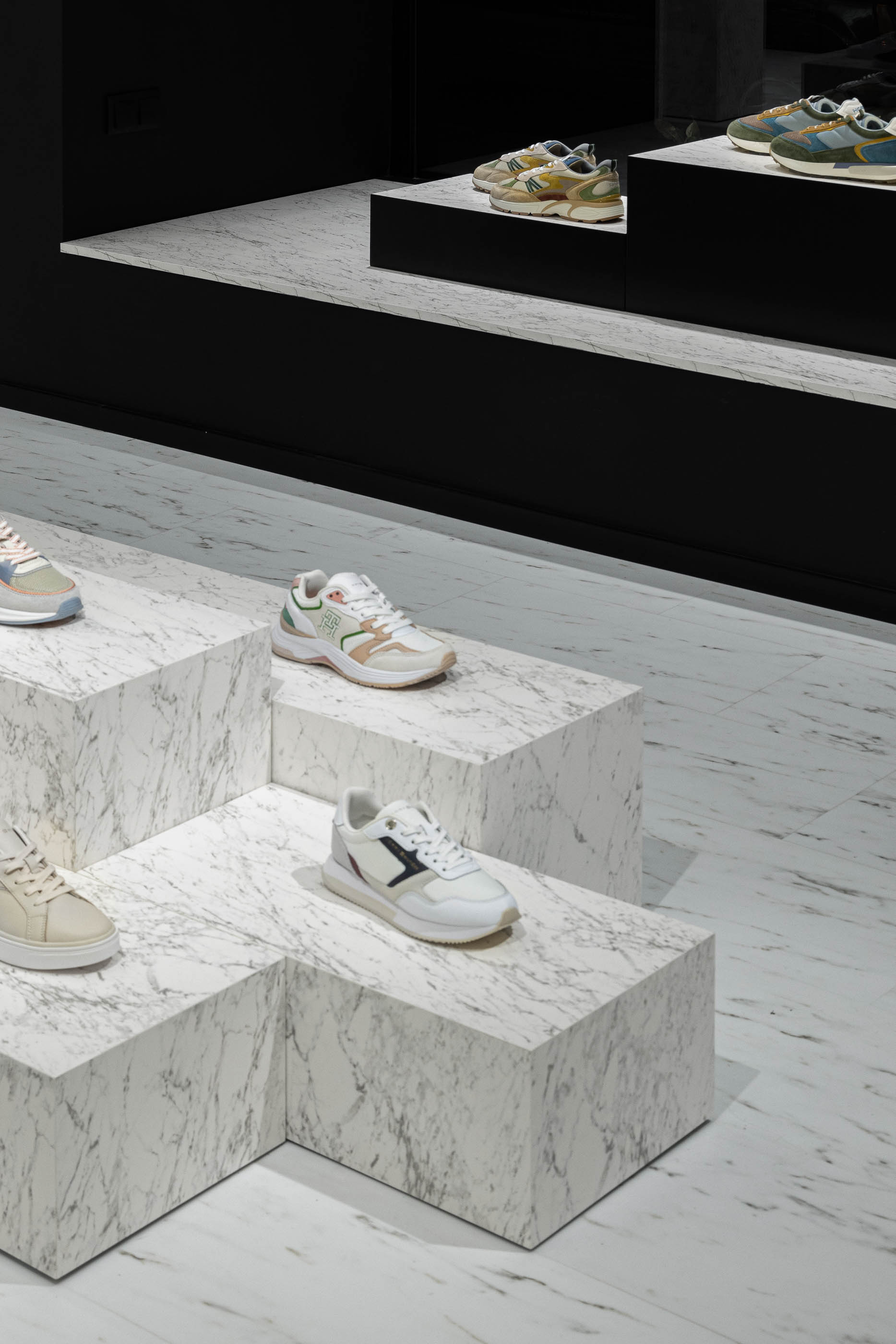 Loja: Detalhe de expositores em mármore branco com calçado e pavimento em mármore. — Walk With Me Store arquitetura REM'A Arquitectos em Porto