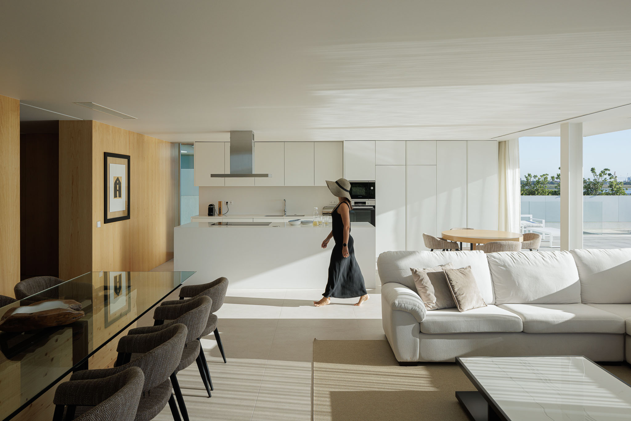 Cozinha: Cortinas brancas, armários brancos e vista para a ria através de grandes janelas. — Moradia JD2 arquitetura Rui Rosmaninho Arquiteto em Ílhavo