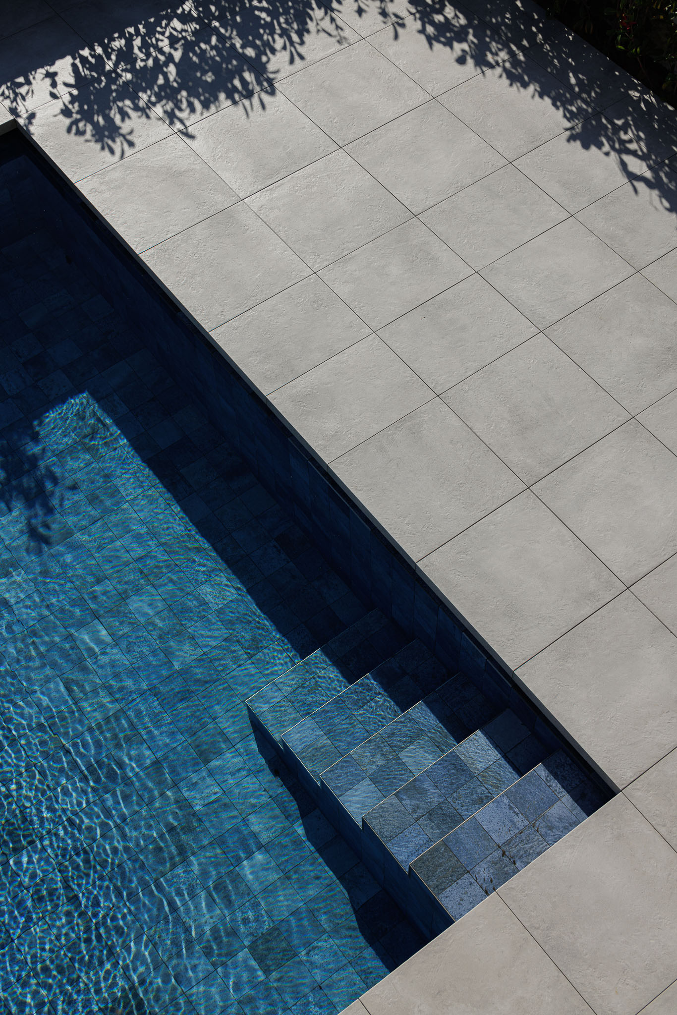 Exterior: Detalhe da fachada com elementos curvos, varandas com guarda em vidro e revestimento vertical branco. — Moradia JD2 arquitetura Rui Rosmaninho Arquiteto em Ílhavo
