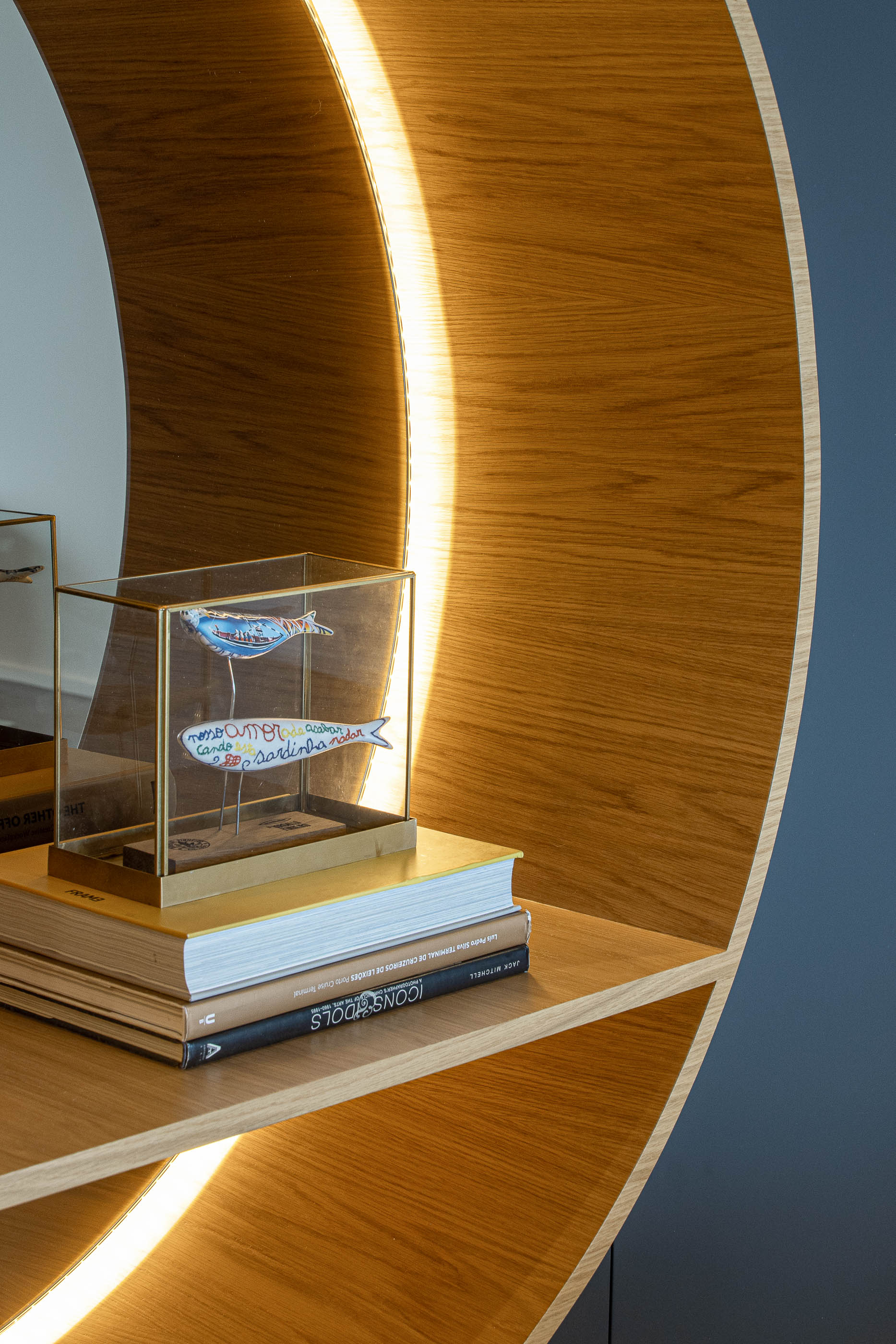 Sala de jantar: Close-up de objetos decorativos em prateleira iluminada, com fundo em madeira clara. — Wave Apartment arquitetura arQB architecture em Póvoa de Varzim