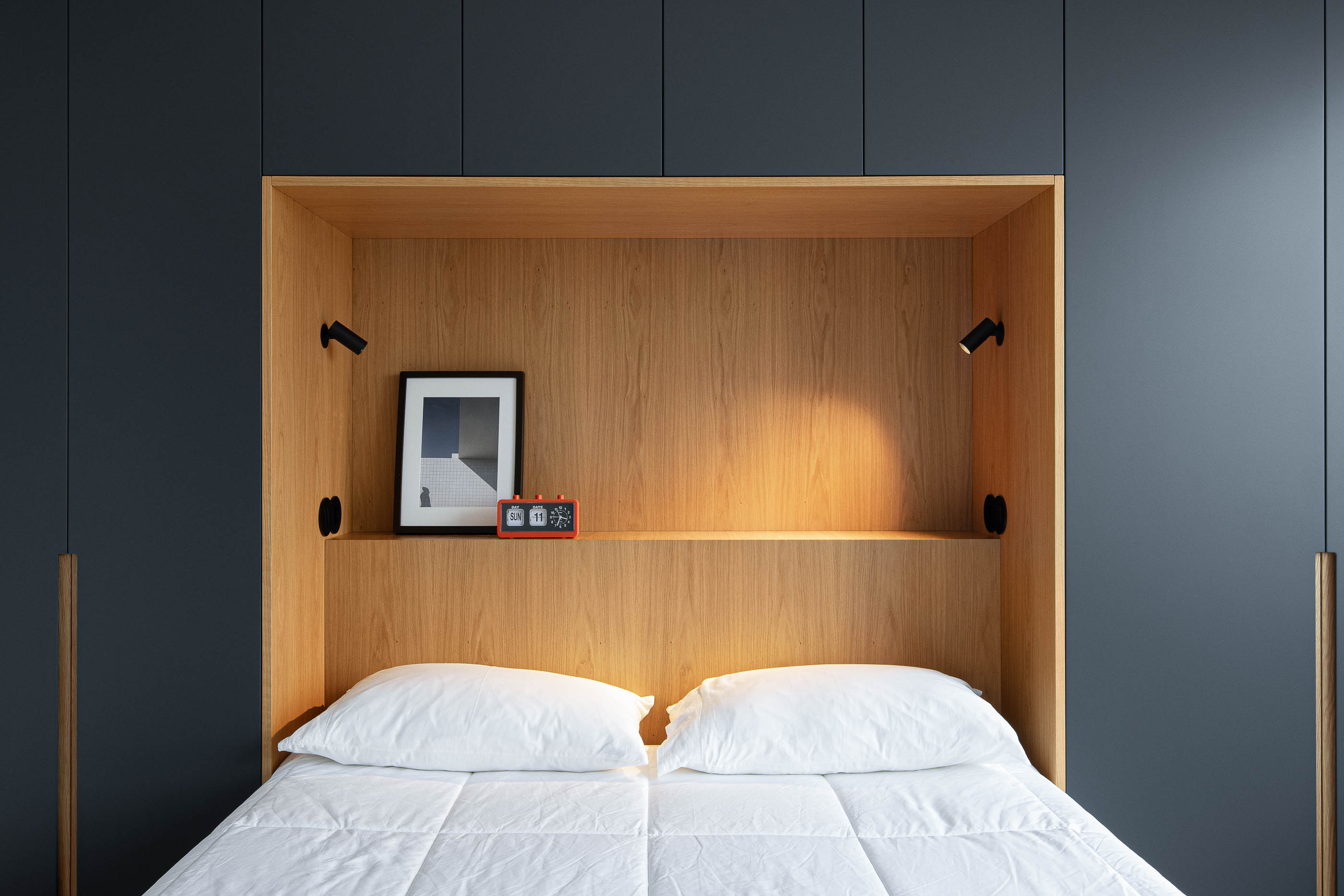 Quarto: Close-up da secretária com garrafa de água, copo, candeeiro e cadeira, com vista para a cidade. — Wave Apartment arquitetura arQB architecture em Póvoa de Varzim