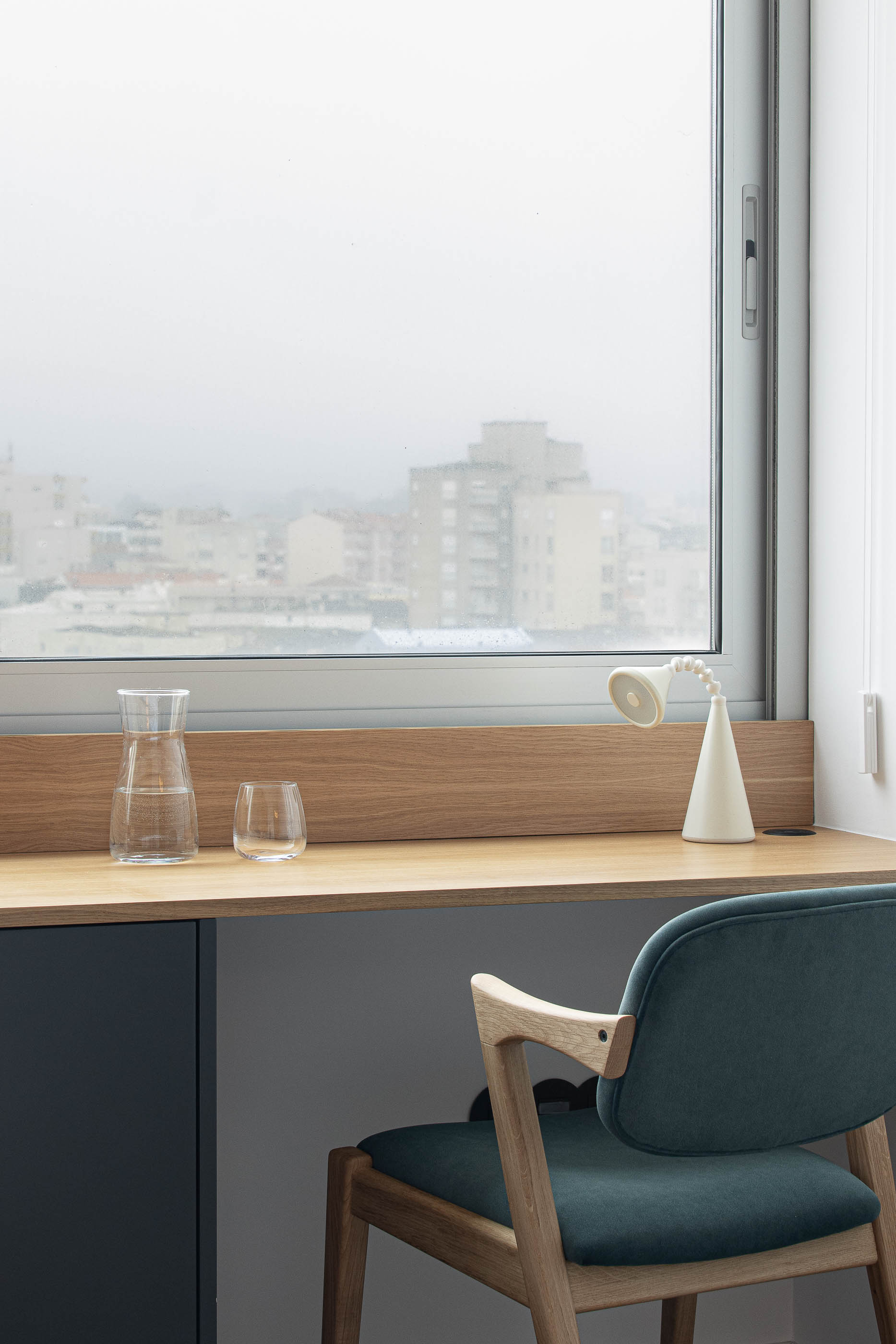 Quarto: Detalhe da cabeceira em madeira clara com candeeiro de parede preto e moldura com fotografia. — Wave Apartment arquitetura arQB architecture em Póvoa de Varzim