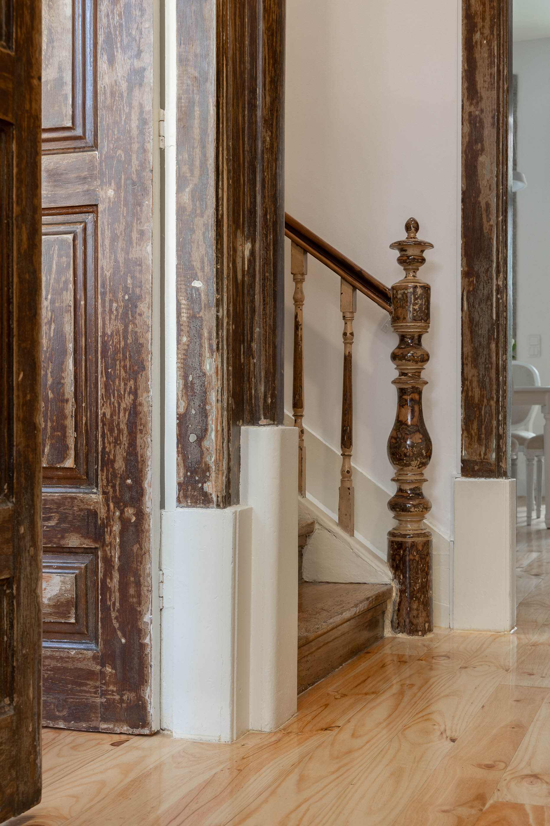 Detalhe da escadaria com corrimão em madeira torneada e pavimento em madeira clara. — Casa Cedofeita arquitetura Paulo Moreira Architectures em Porto