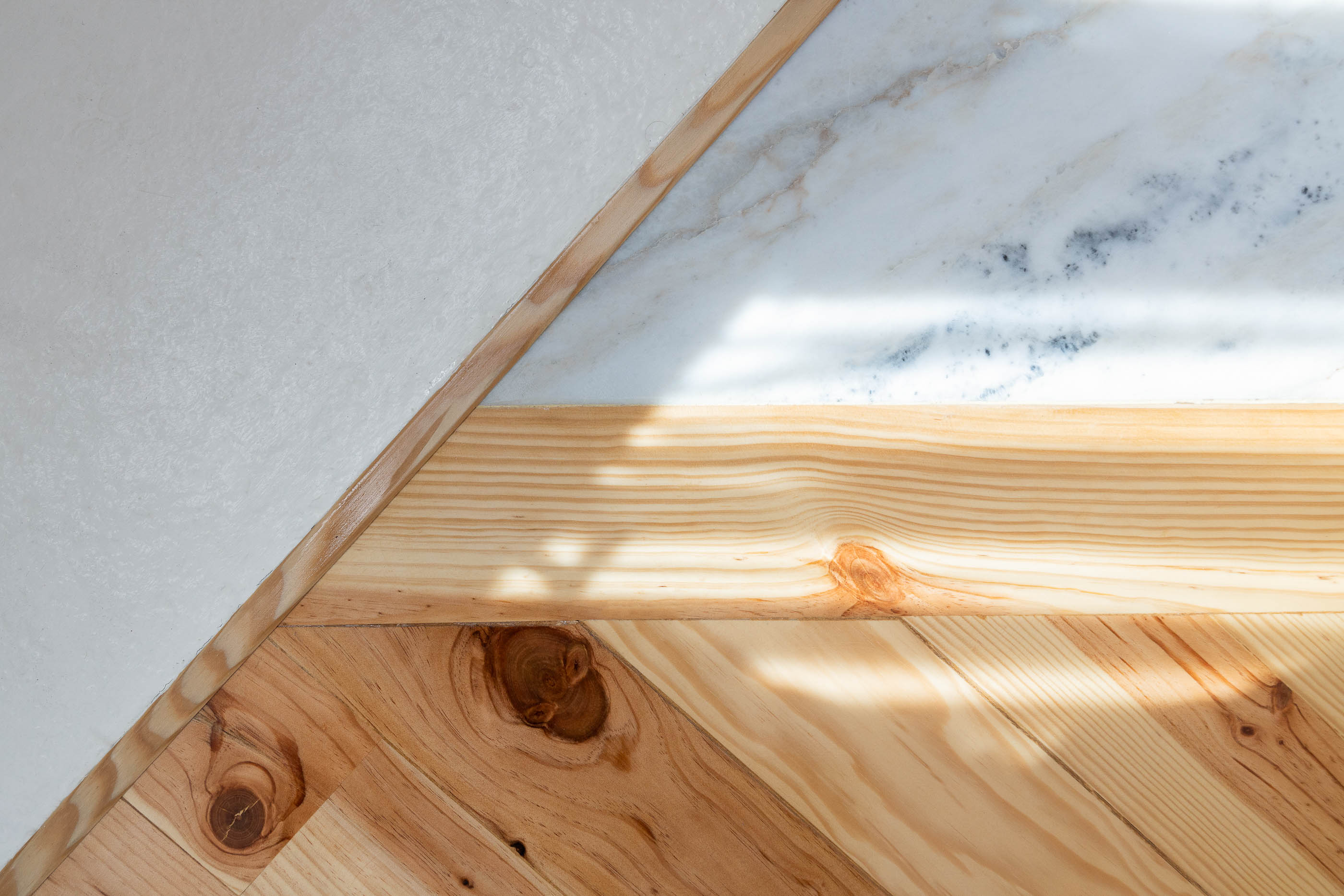 Detalhe da junção de materiais: madeira clara, mármore e parede branca. — Casa Cedofeita arquitetura Paulo Moreira Architectures em Porto