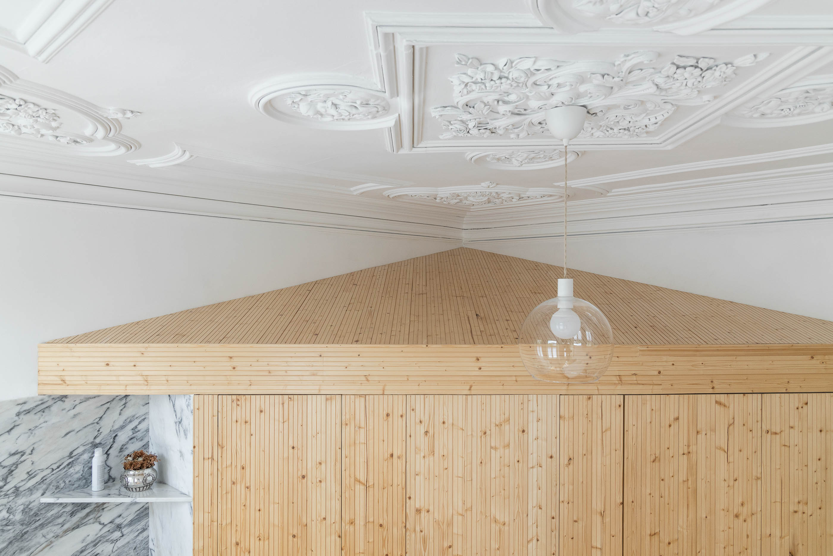 Detalhe do teto com molduras decorativas e roupeiro em madeira clara. — Casa Cedofeita arquitetura Paulo Moreira Architectures em Porto