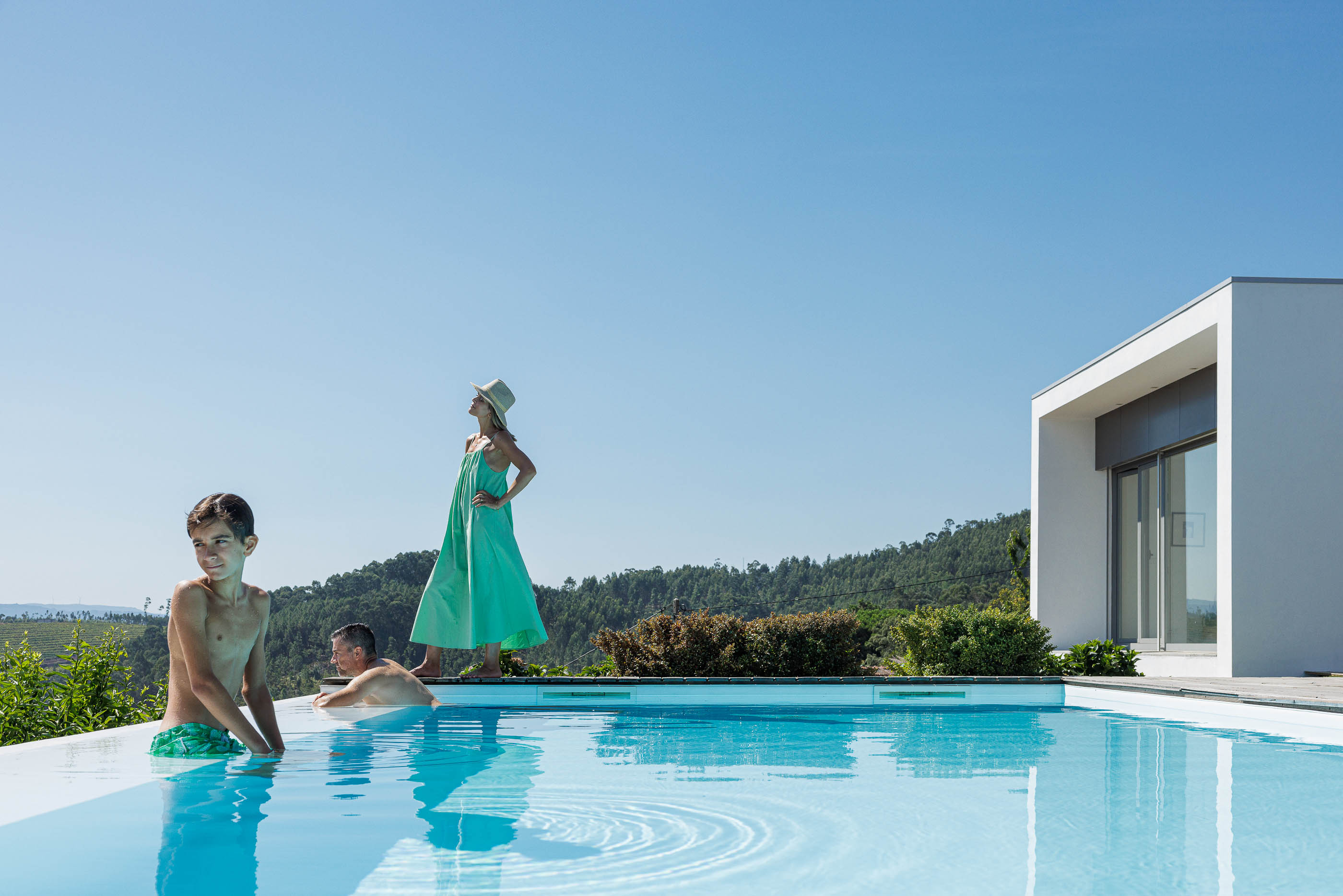 Exterior: Piscina com borda infinita, vista panorâmica e volumes brancos da casa. — Casa do Alto arquitetura Jorge Martins arquiteto em Celorico de Basto