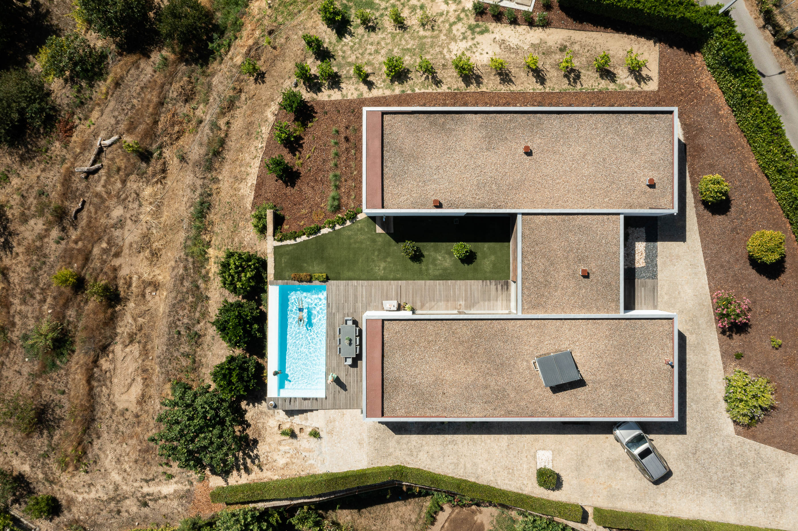 Exterior: Vista aérea da casa com piscina, pátio interior, telhados planos e envolvente natural. — Casa do Alto arquitetura Jorge Martins arquiteto em Celorico de Basto