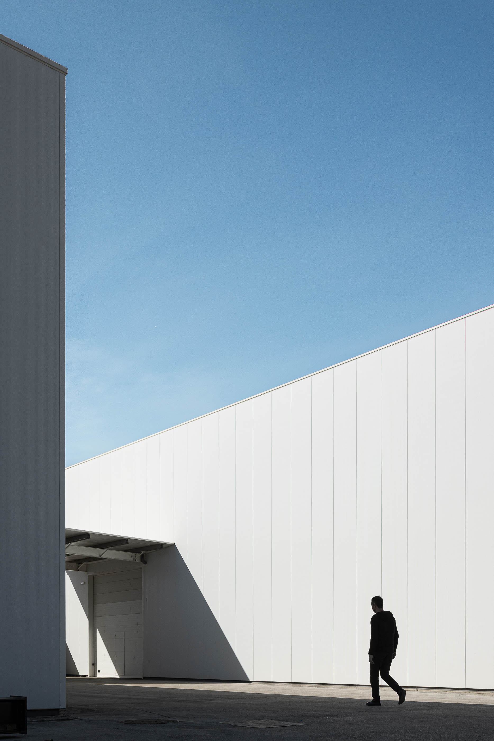 Exterior do edifício com paredes brancas e linhas arquitetónicas minimalistas. — Edifício Sede da PRF arquitetura Impare Arquitectura em Leiria