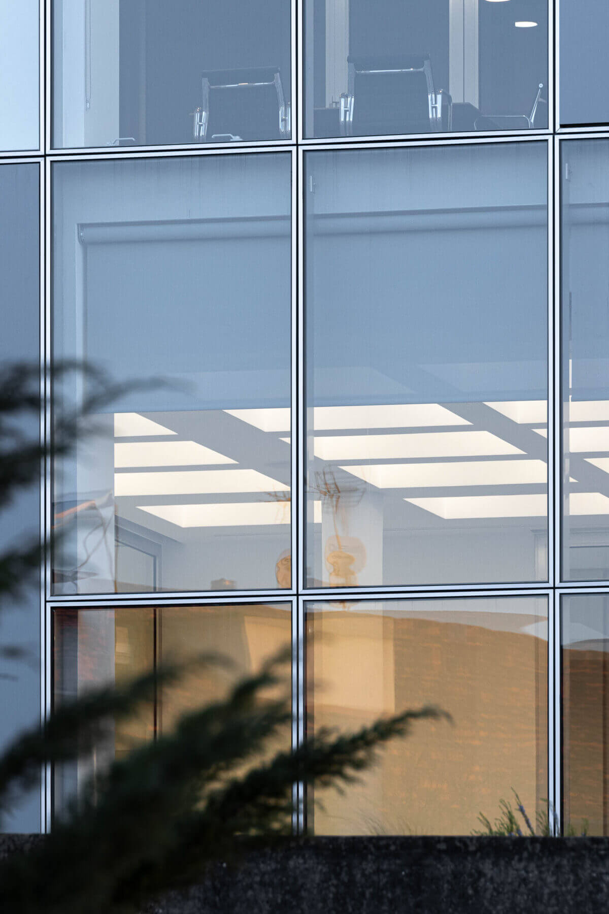 Detalhe da fachada com janelas e vista para o interior da sala de reuniões. — Edifício Sede da PRF arquitetura Impare Arquitectura em Leiria