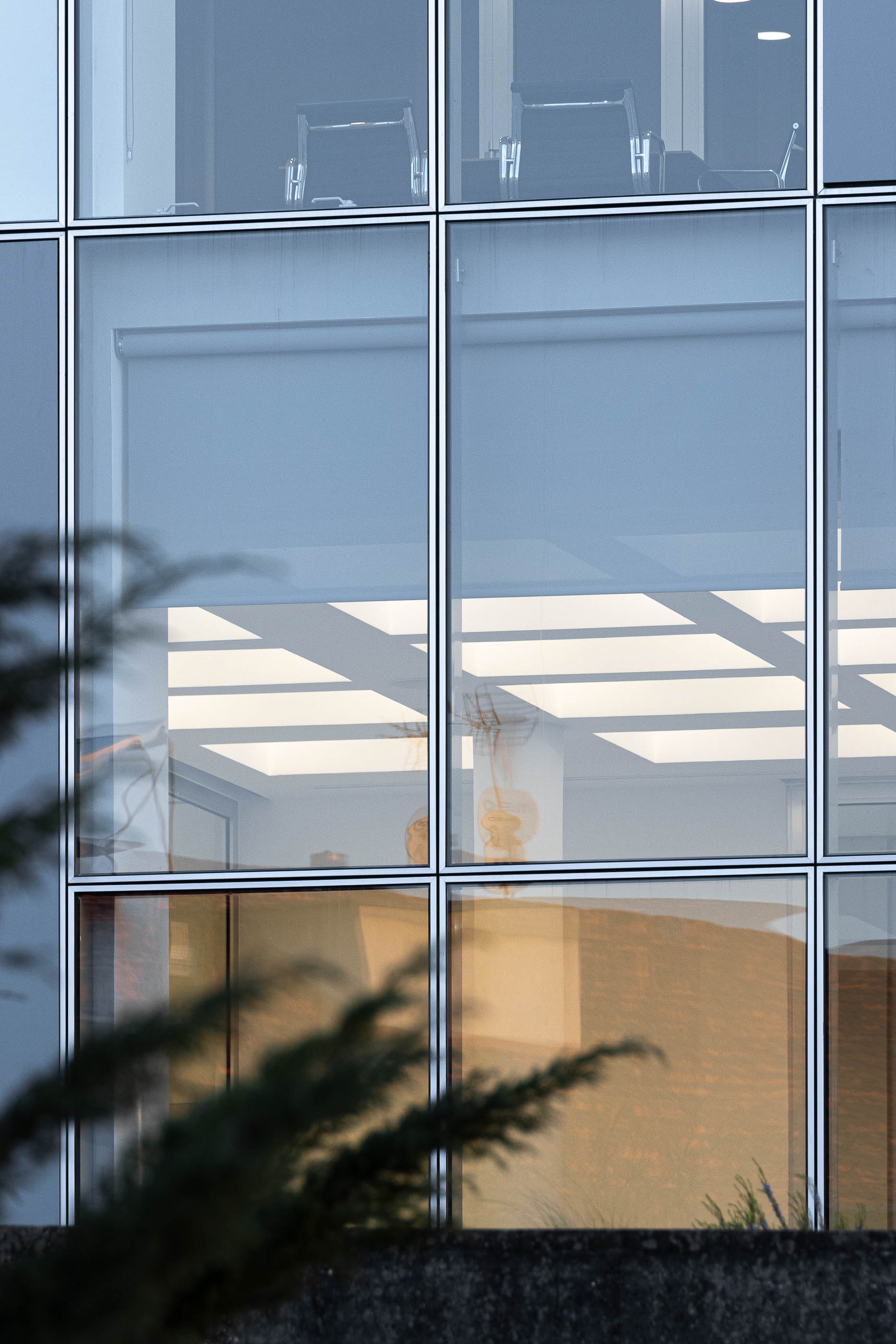 Detalhe da fachada com janelas e vista para o interior da sala de reuniões. — Edifício Sede da PRF arquitetura Impare Arquitectura em Leiria
