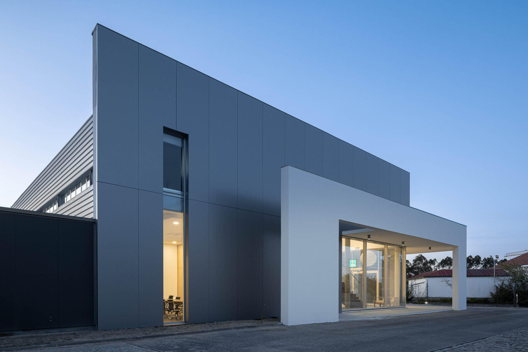 Entrada principal do edifício com escadas em madeira e candeeiro esférico. — Edifício Sede da PRF arquitetura Impare Arquitectura em Leiria